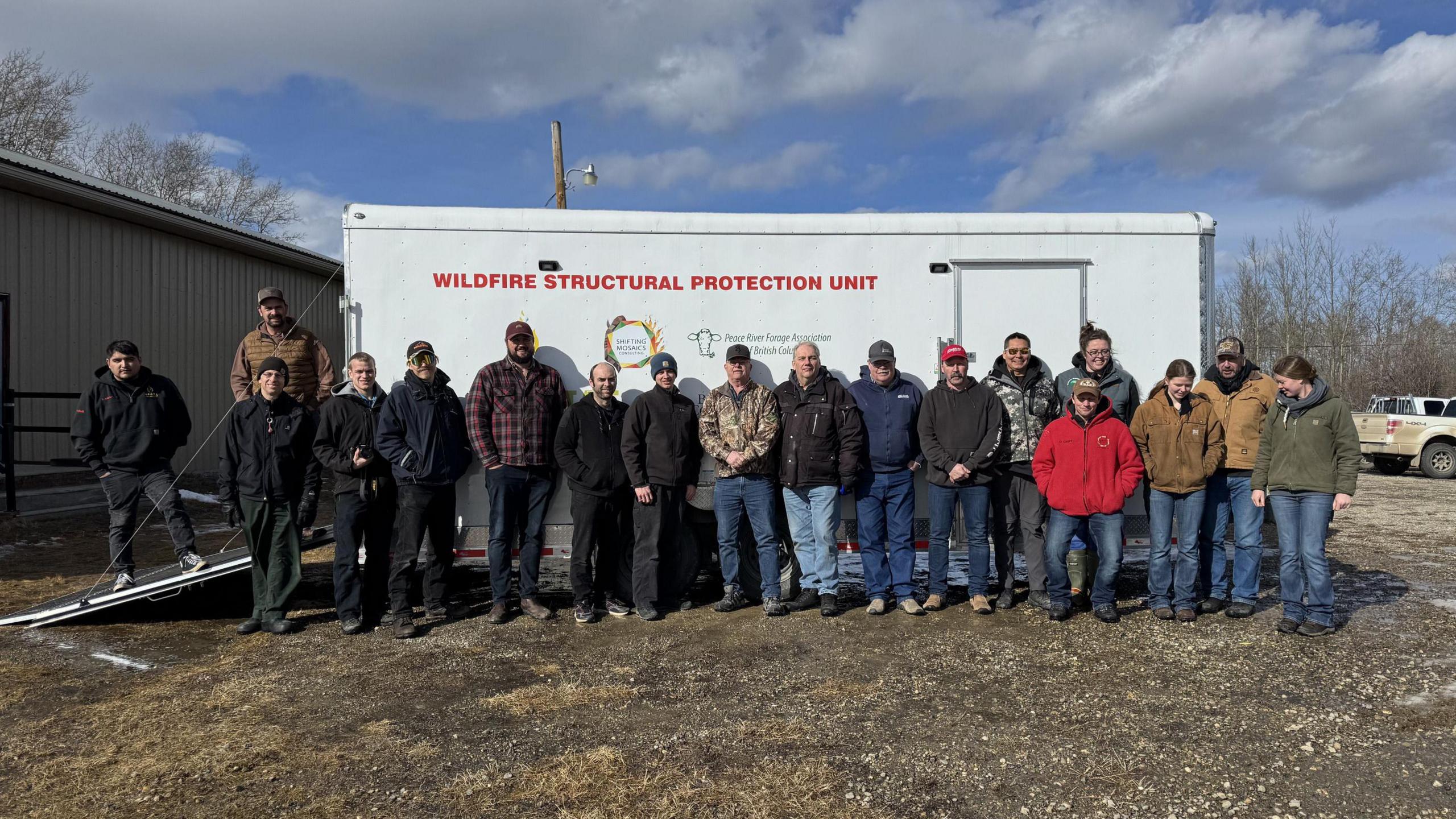 Members of the Northeast BC Rural Incident Management Team in front of a fire protection wagon they purchased using funds from donations and grants.