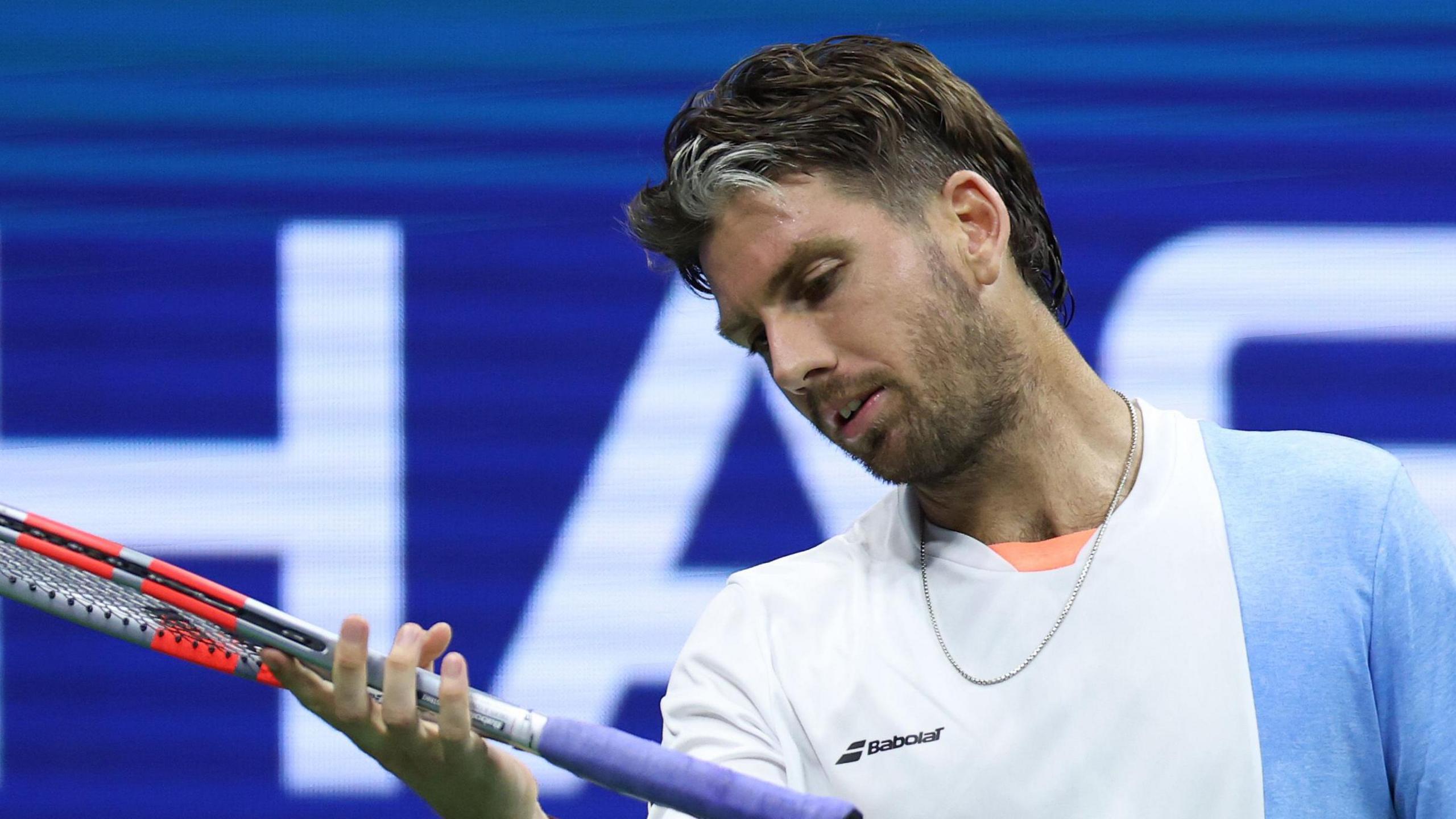 Cameron Norrie looks at his racquet during a 2025 US Open defeat by Novak Djokovic