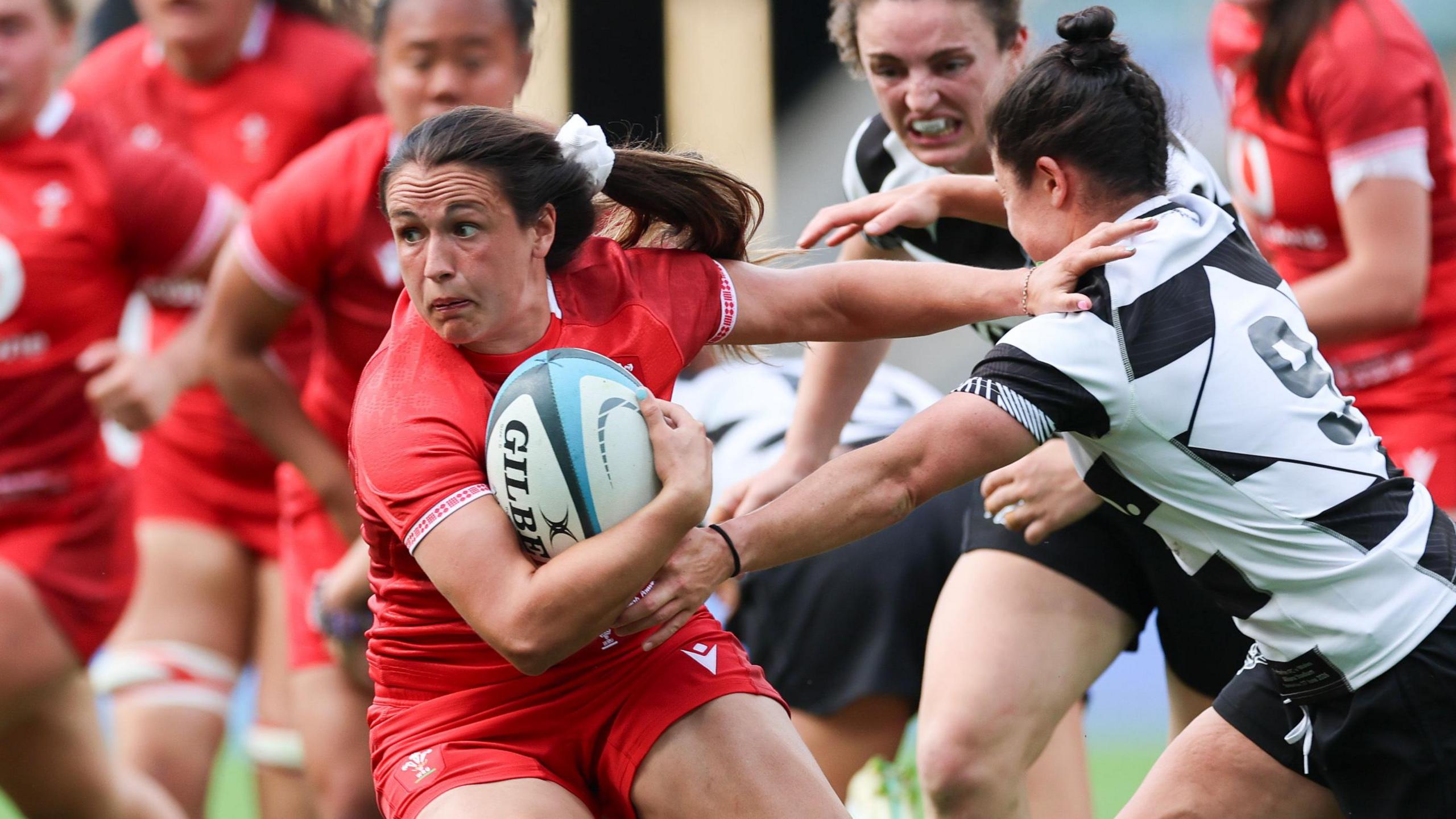 Kayleigh Powell of Wales fends off a Barbarians player