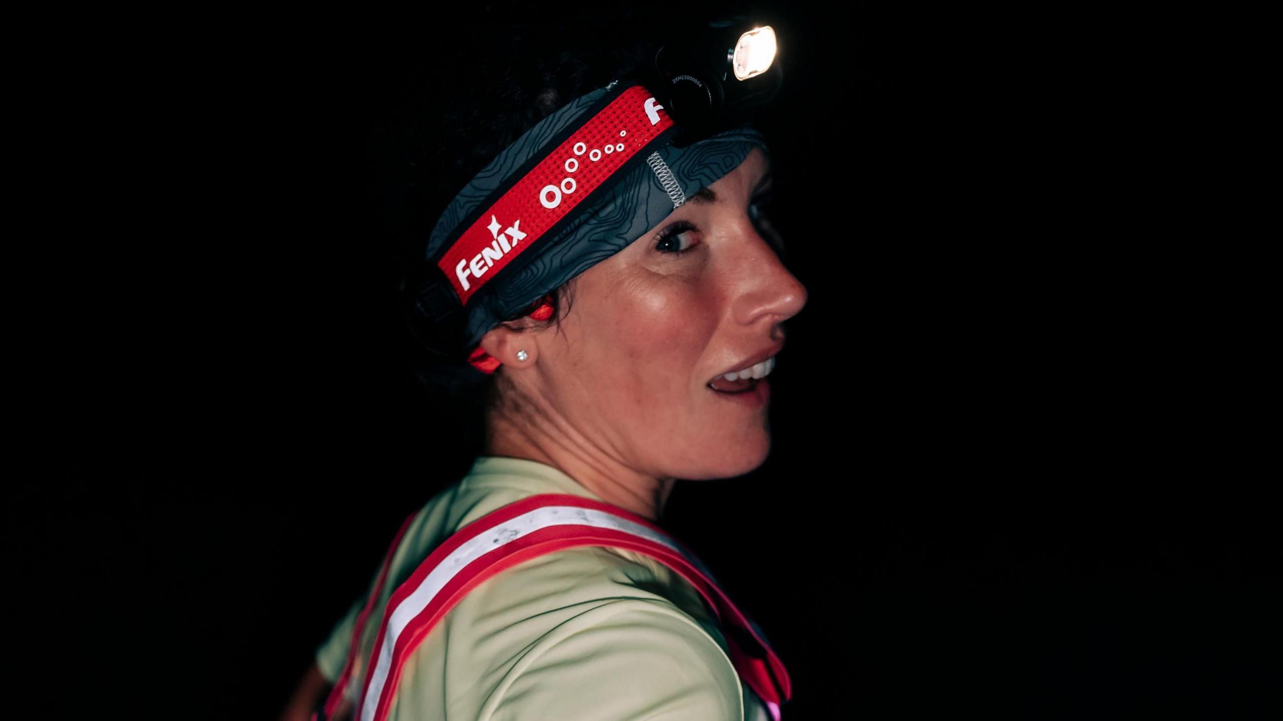 Sophie Power running with a head torch on