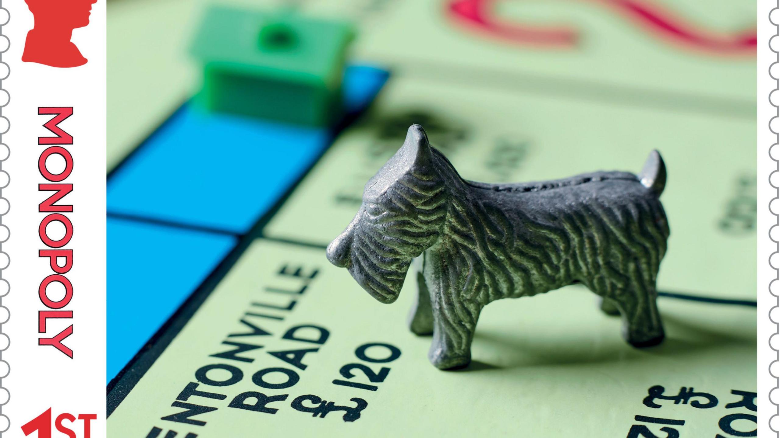 A close-up of a special-edition stamp featuring a Monopoly board with a red house and a metal dog.