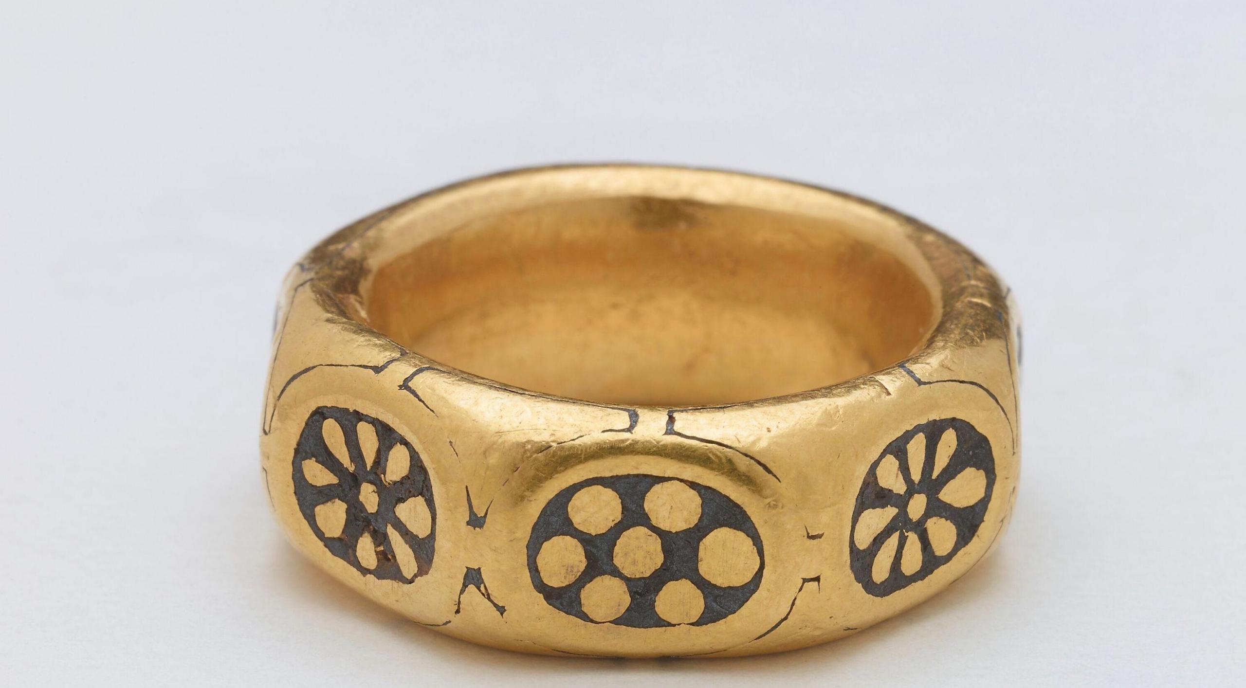 The large gold ring has eight sides. On each side is an inlet of lead with an ornate pattern.