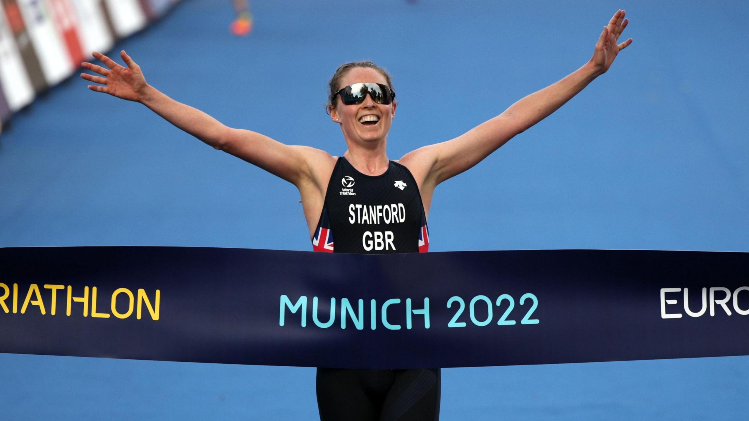 Non Stanford yn dathlu ennill aur yn y treiathlon elit i fenywod ym Mhencampwriaethau Ewrop ym Munich yn 2022