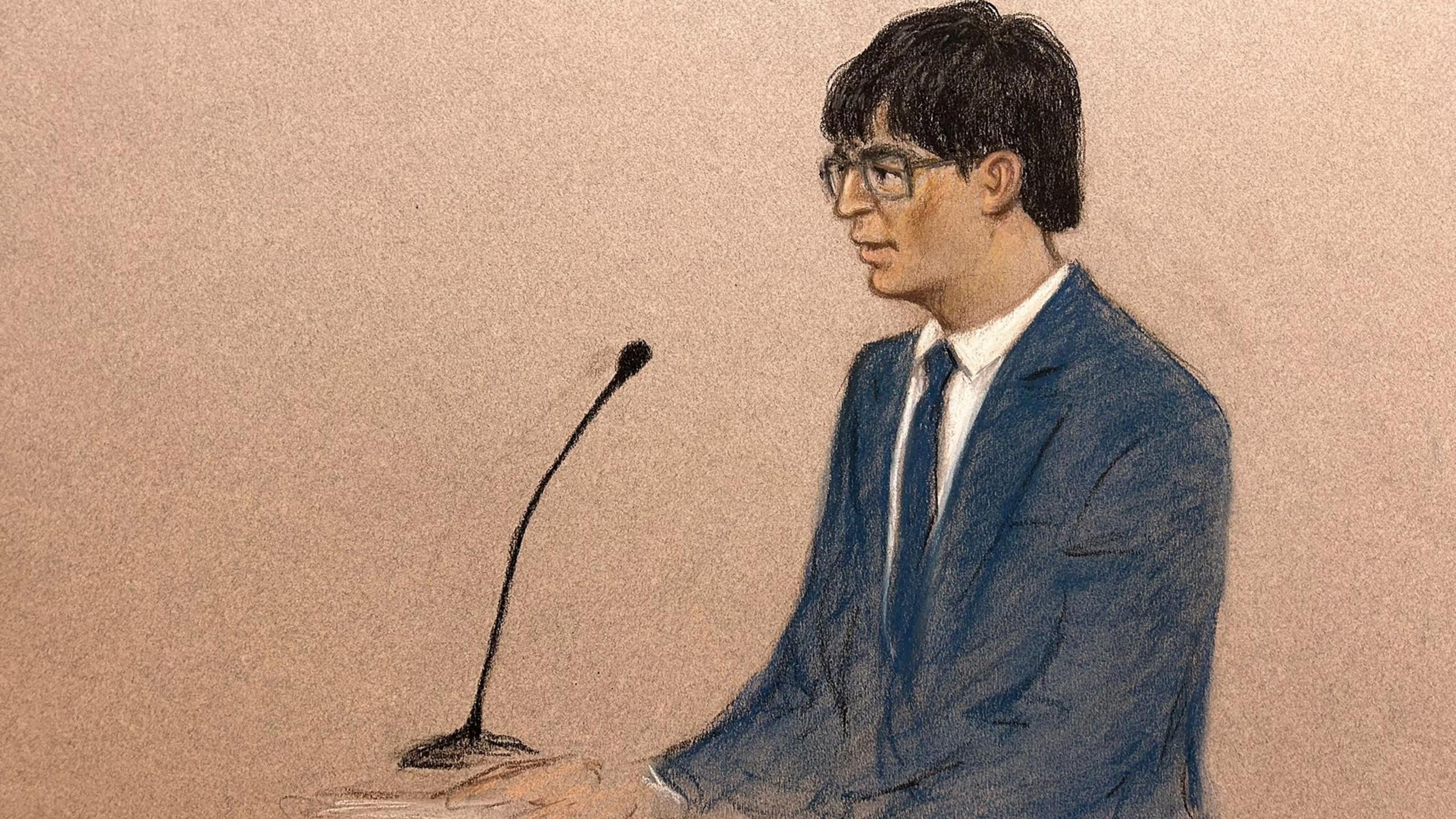 A court sketch of the defendant, who is sitting in the dock, wearing a blue suit with a white shirt and blue tie. He has short black hair and is wearing glasses.