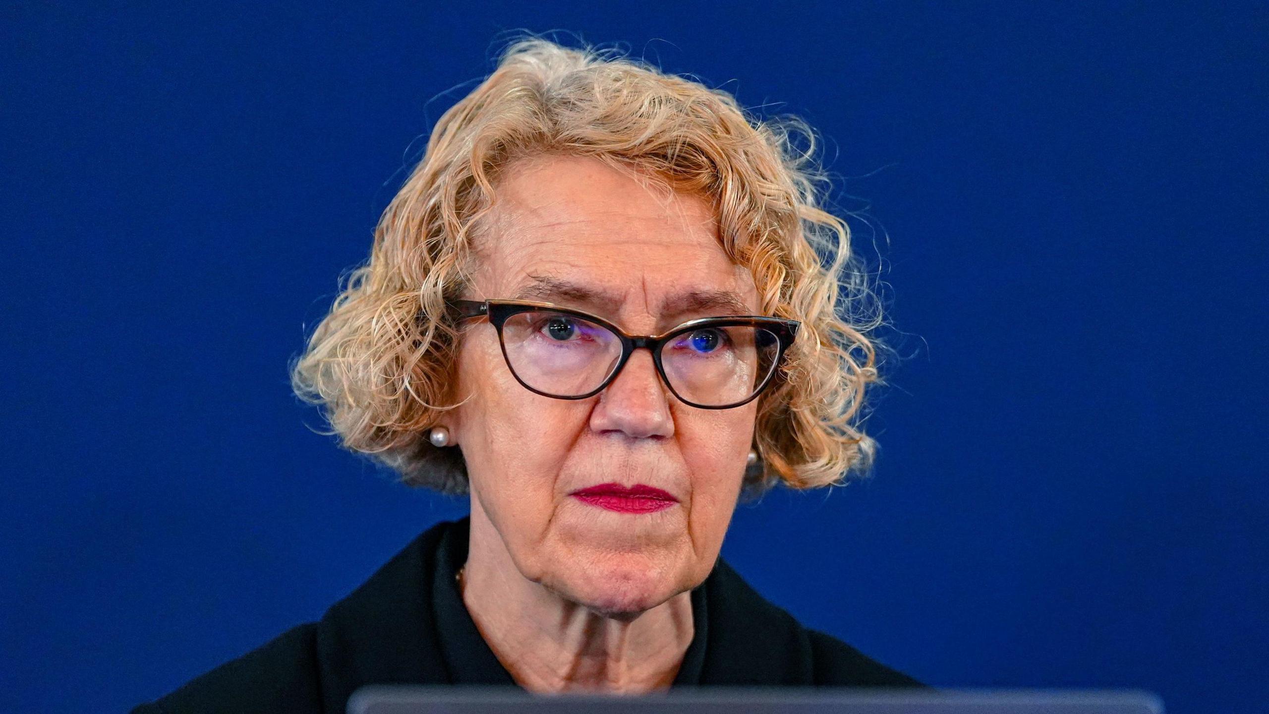 Chair of the inquiry Lady Justice Thirlwall at Liverpool Town Hall. She has cropped curly blonde hair and wears dark coloured glasses. She is wearing dark coloured, smart clothing. 