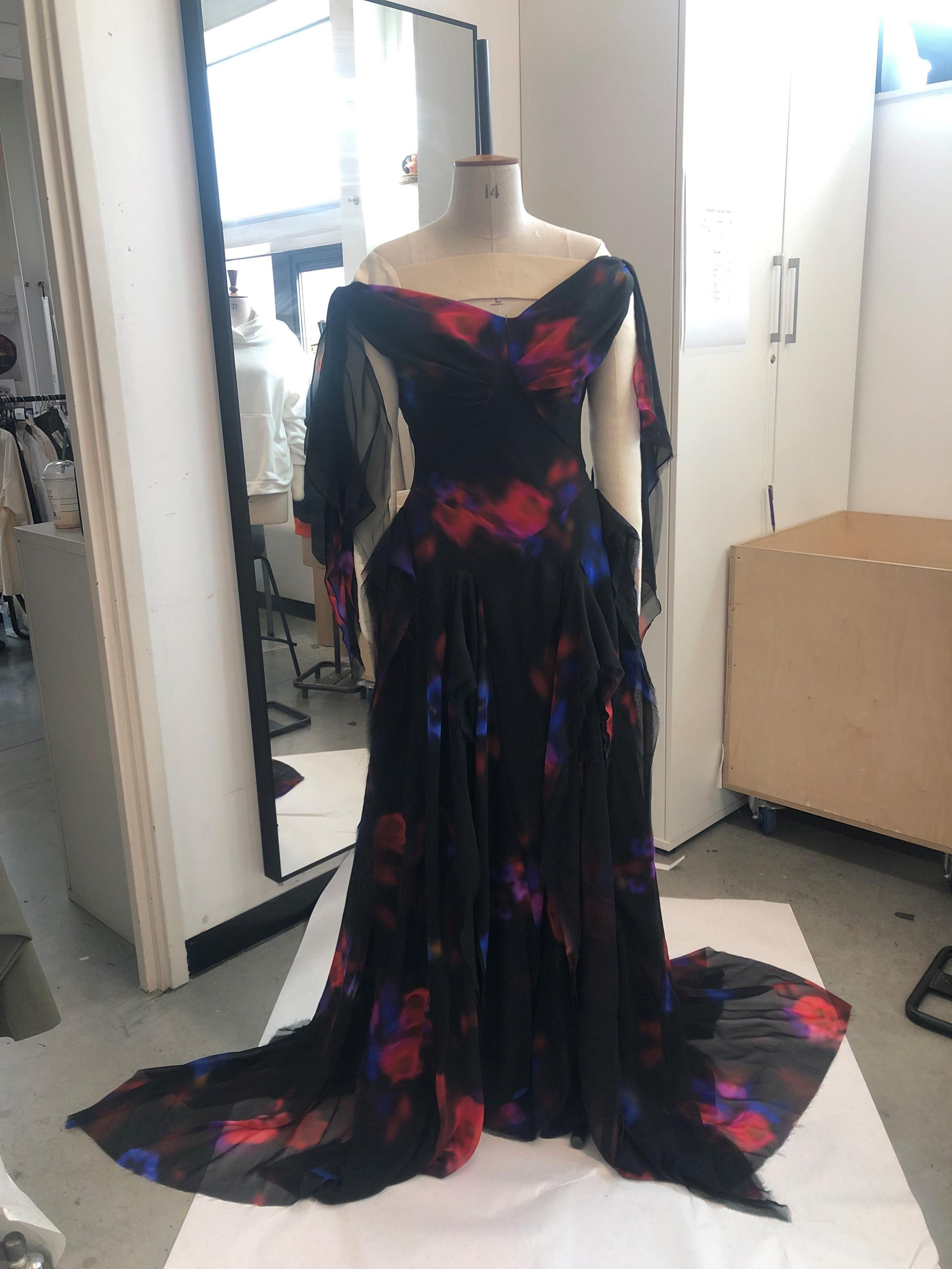 A black dress with red and blue detail on a mannequin