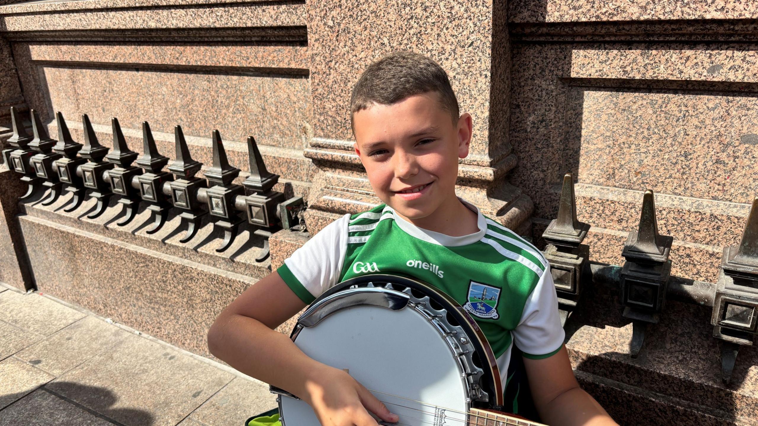Young boy in green top playing banjo