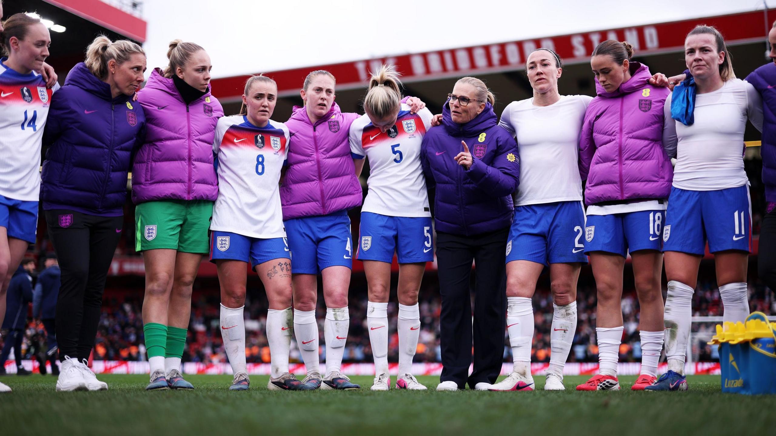 Sarina Wiegman in a huddle with England players 