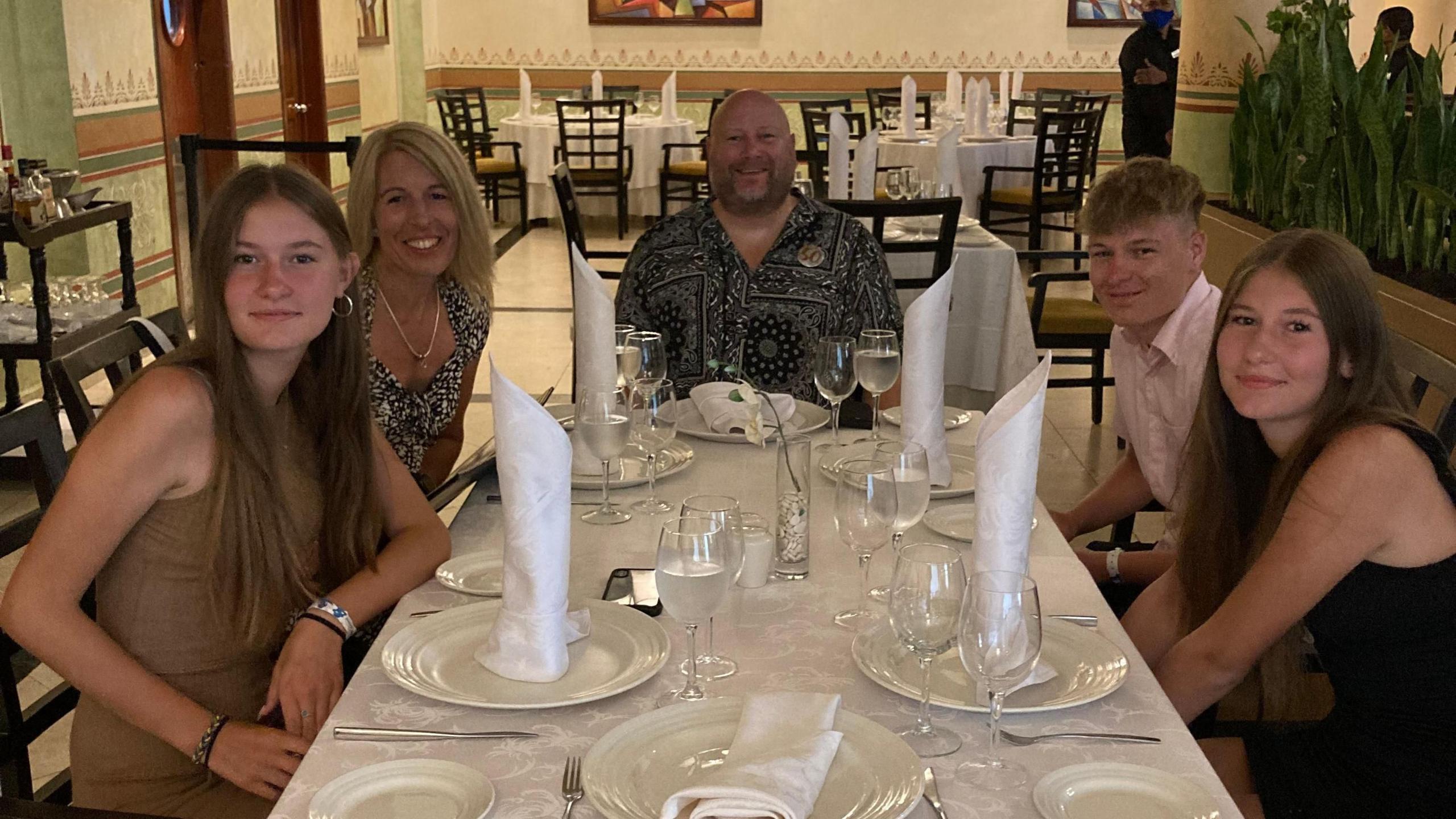 Ethan Goddard with his parents and twin sisters sitting round a table at a restaurant