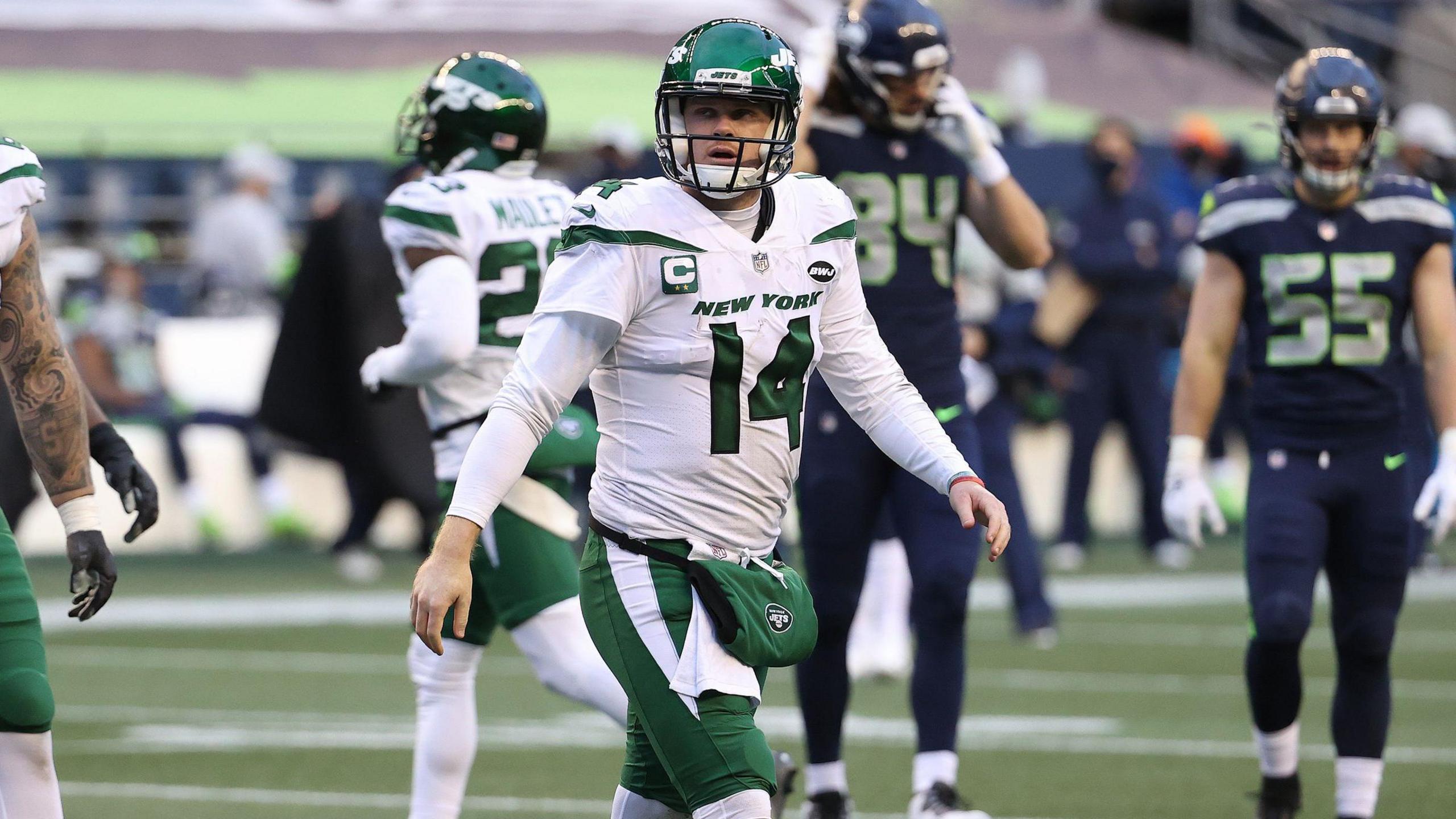 Sam Darnold walks off the field playing for the New York Jets