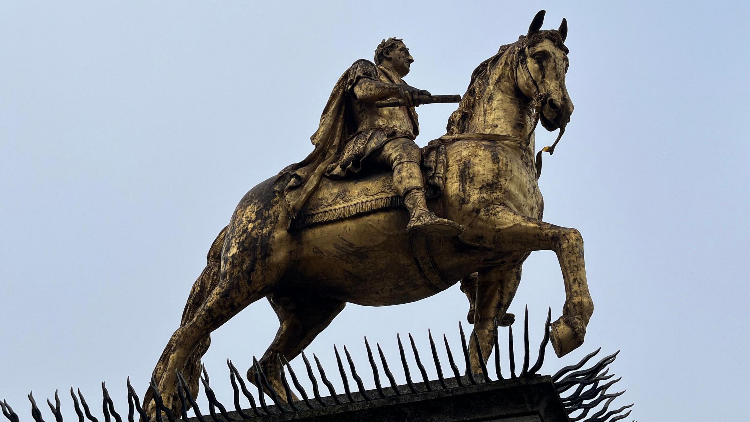 A full view of the statue depicting King William III holding a scroll and riding a horse