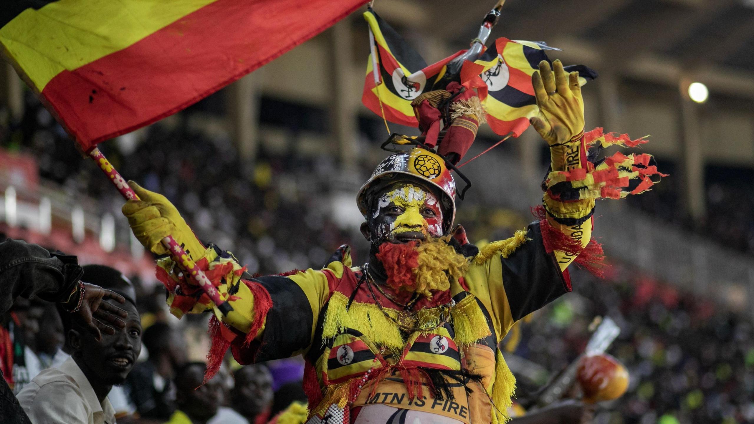 A Uganda fan is dressed colourfully in the national colours of yellow, red and black