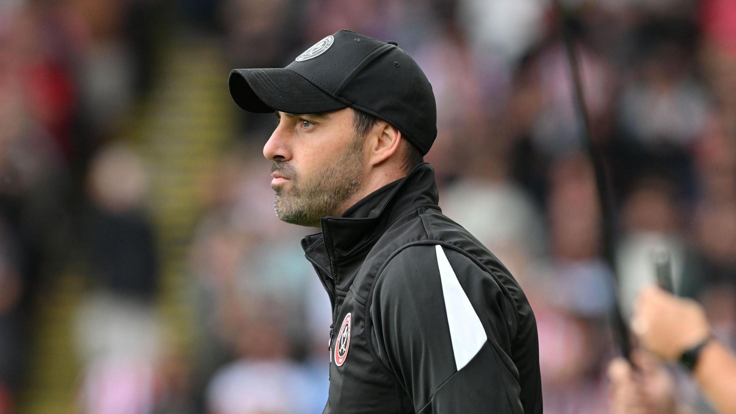 Sheffield United boss Ruben Selles stands in the dugout watching the match action with his lips pursed