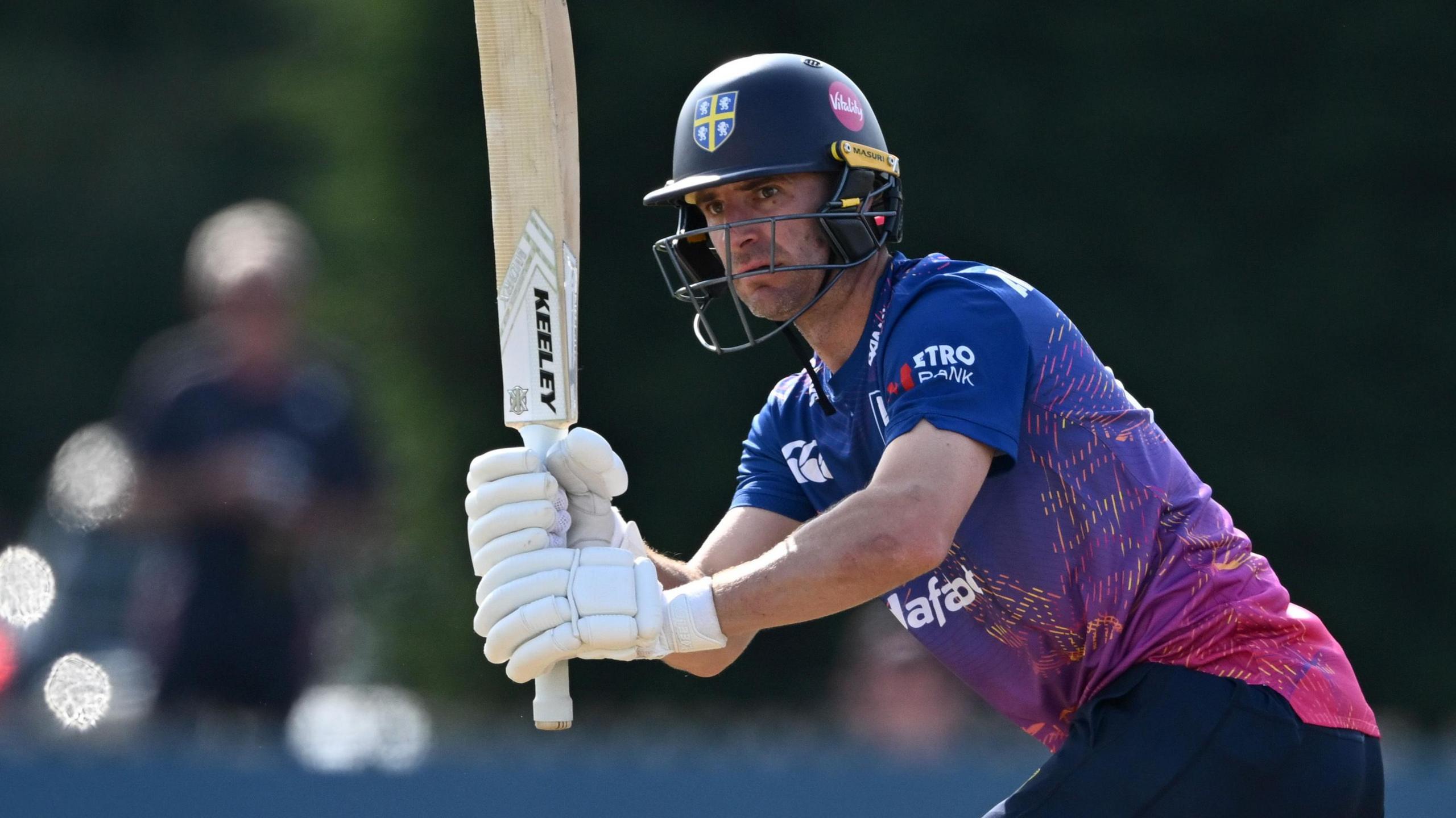 Right-handed bat Colin Ackermann with his bat raised and his head looking to the left after playing a shot through the legside