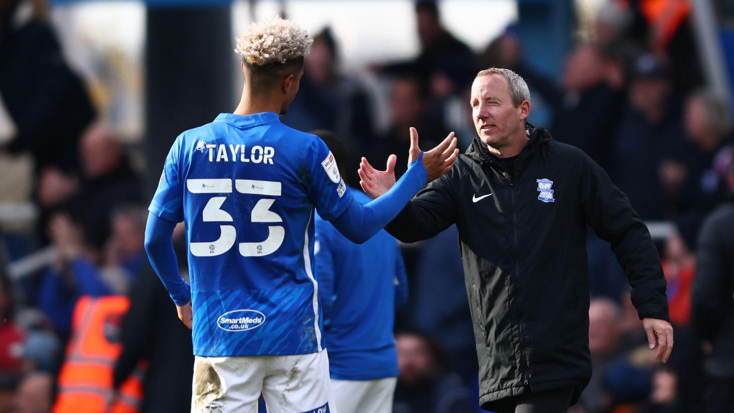 Lee Bowyer clasps hands with Lyle Taylor