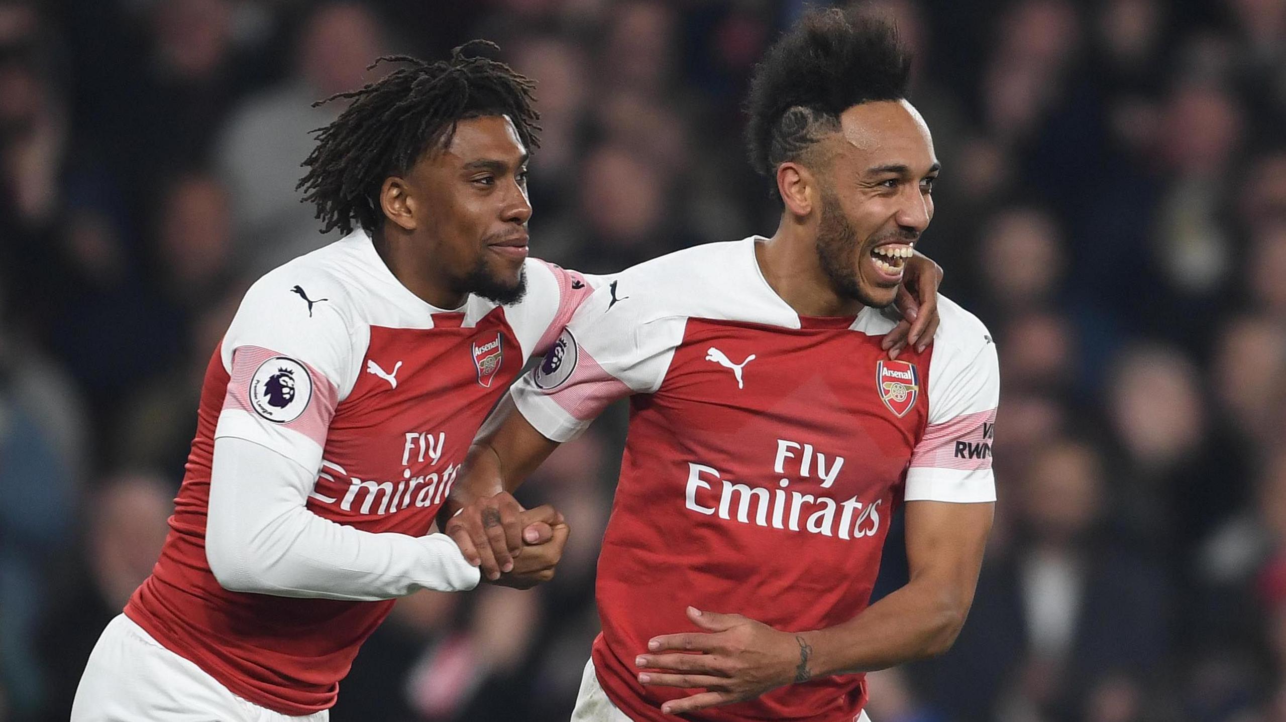 Alex Iwobi puts his left arm around the shoulder of Pierre Emerick-Aubameyang at Arsenal