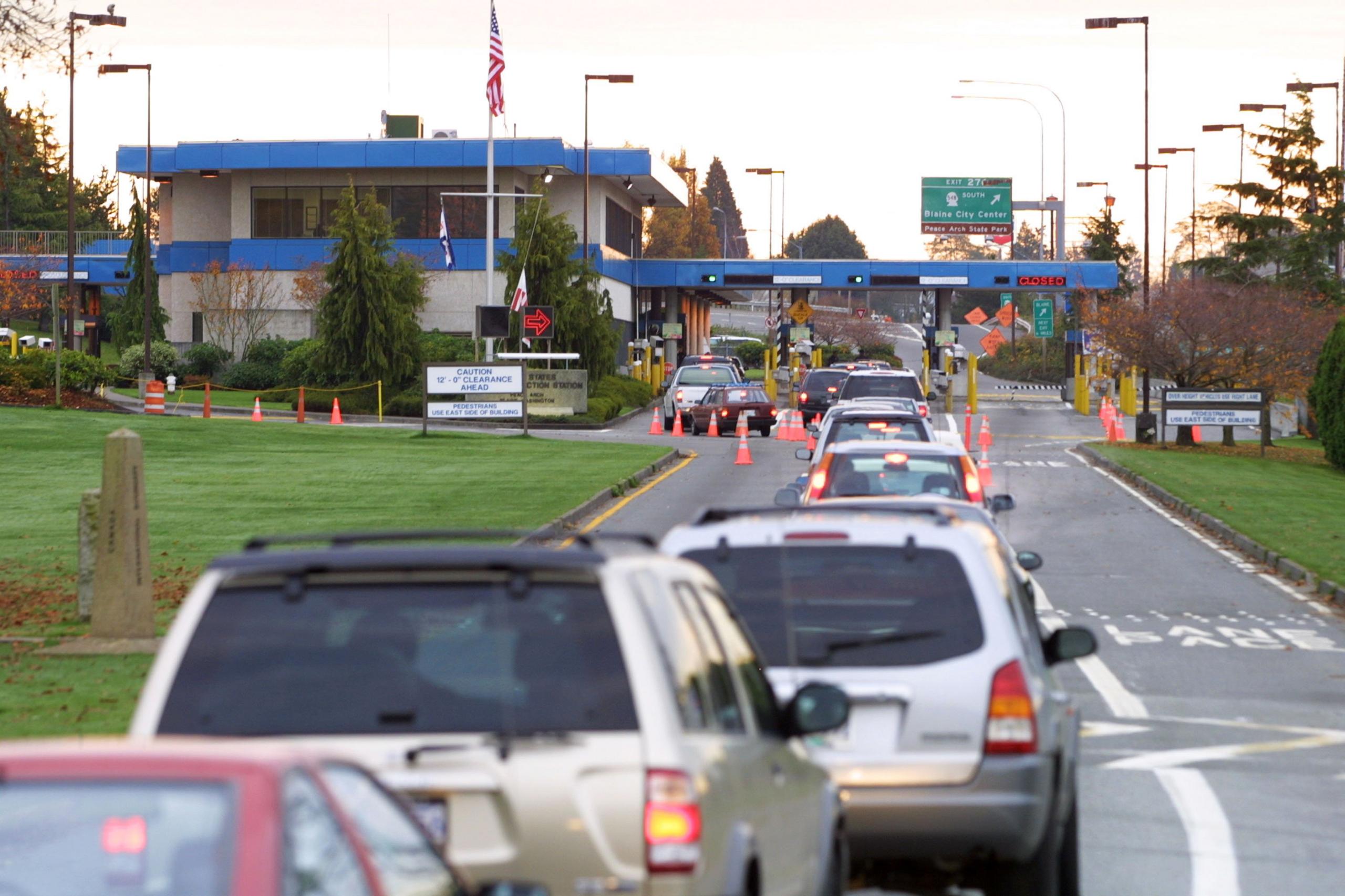 Vehicles line up to enter the United States at the border crossing between Blaine, Washington and White Rock, British Columbia November 8, 2001 in White Rock, BC.