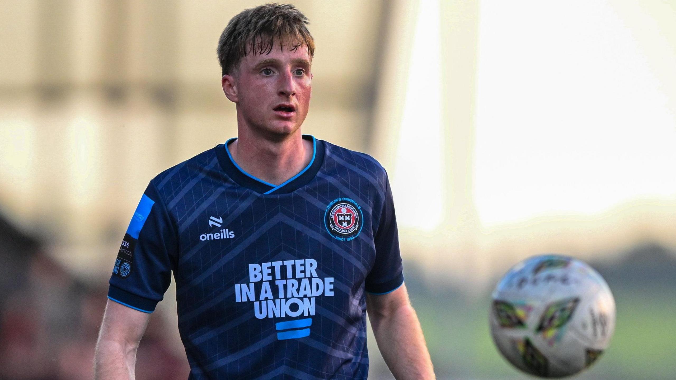 A photo of Jevon Mills, wearing a blue Bohemians kit, watching the ball during their game against Derry City in May 2024