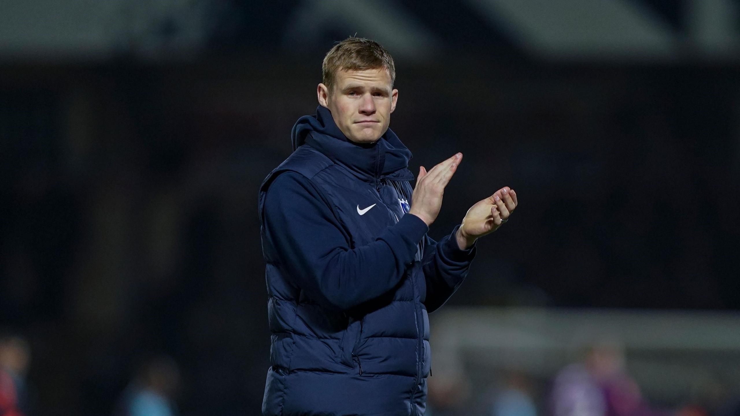 Portsmouth defender Rob Atkinson in his tracksuit applauds the Pompey fans after a loss at Wycombe Wanderers in the FA Cup.