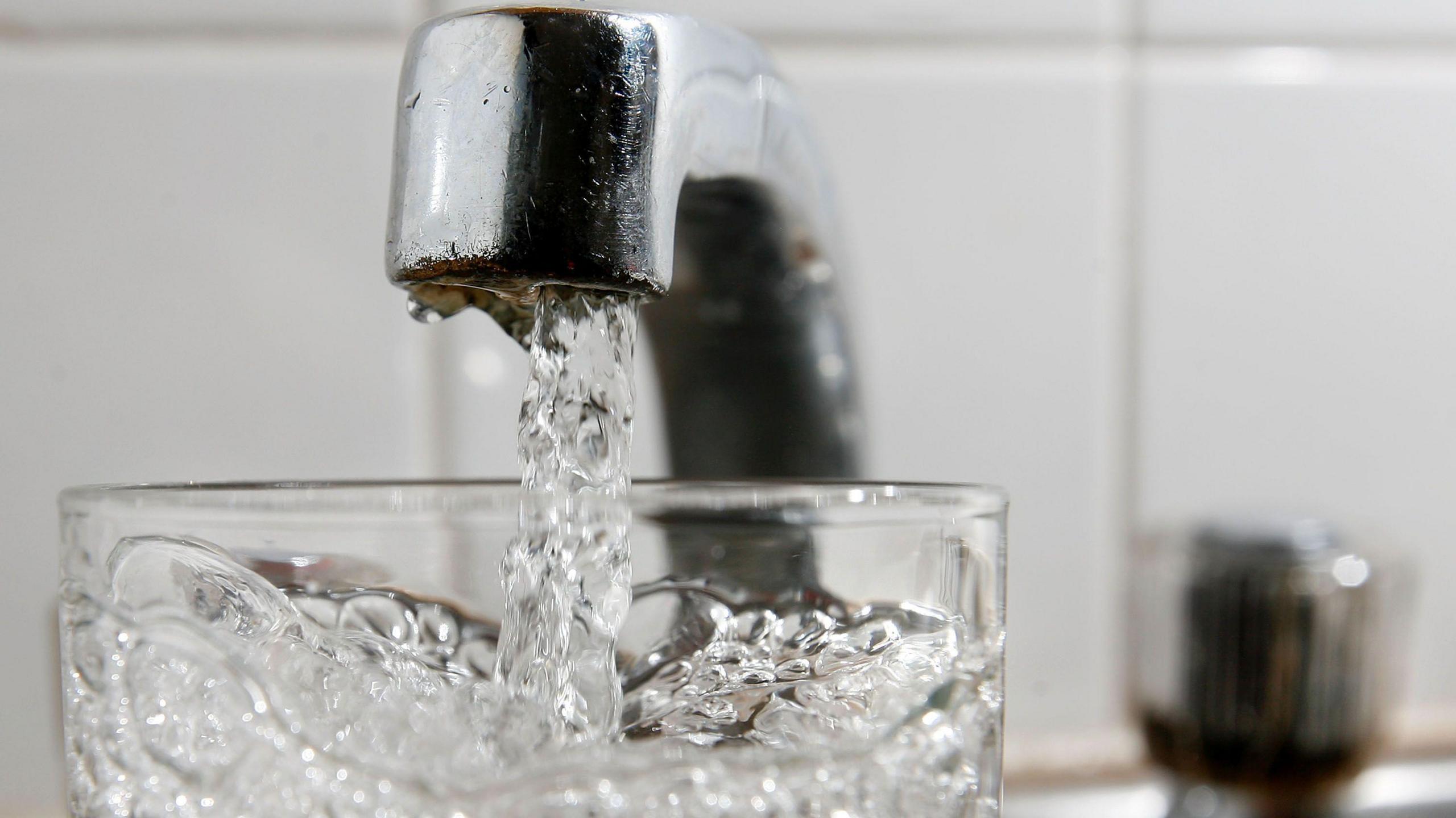 Water from a tap going into a glass