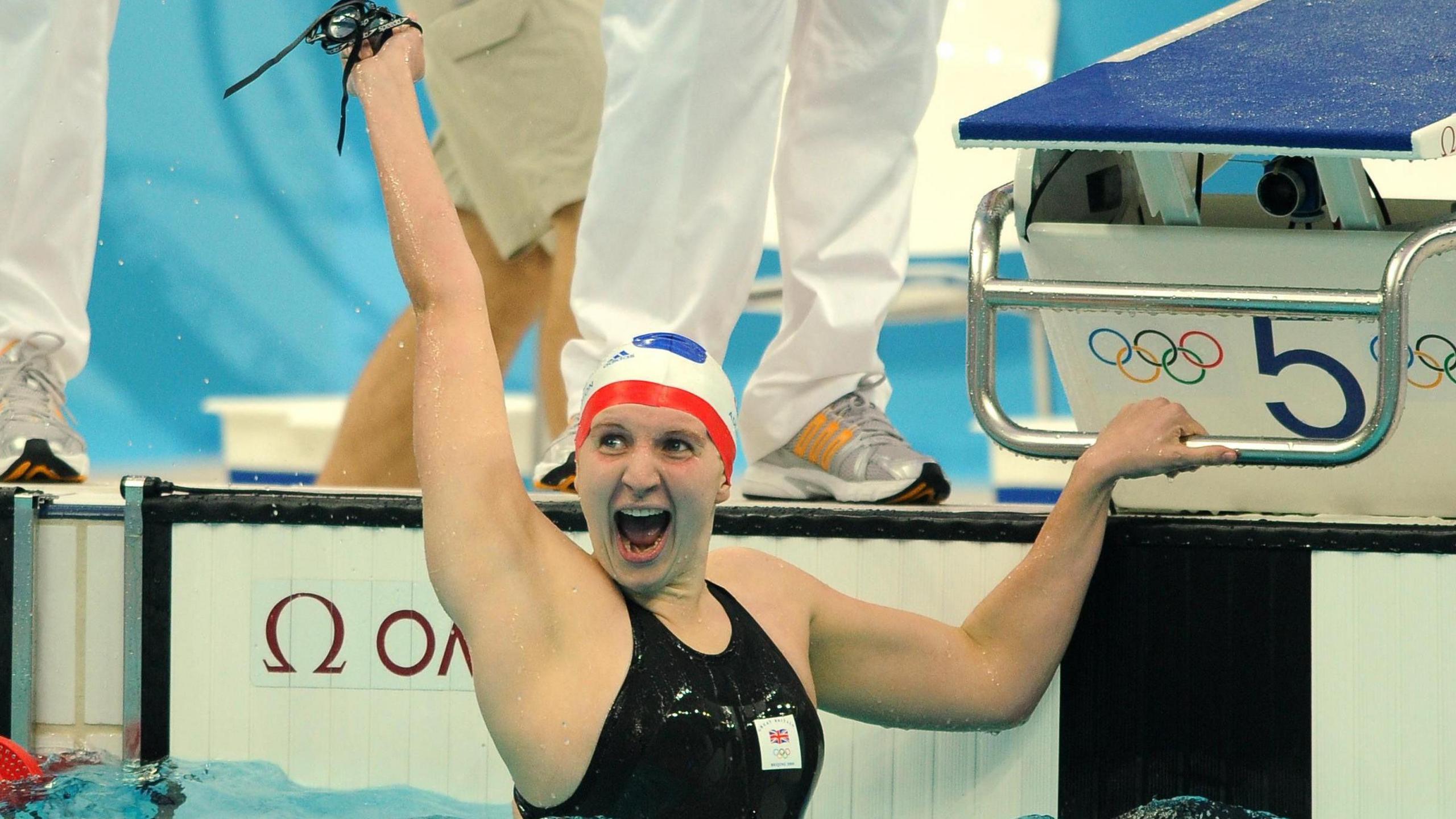 A swimmer celebrating a win in a pool