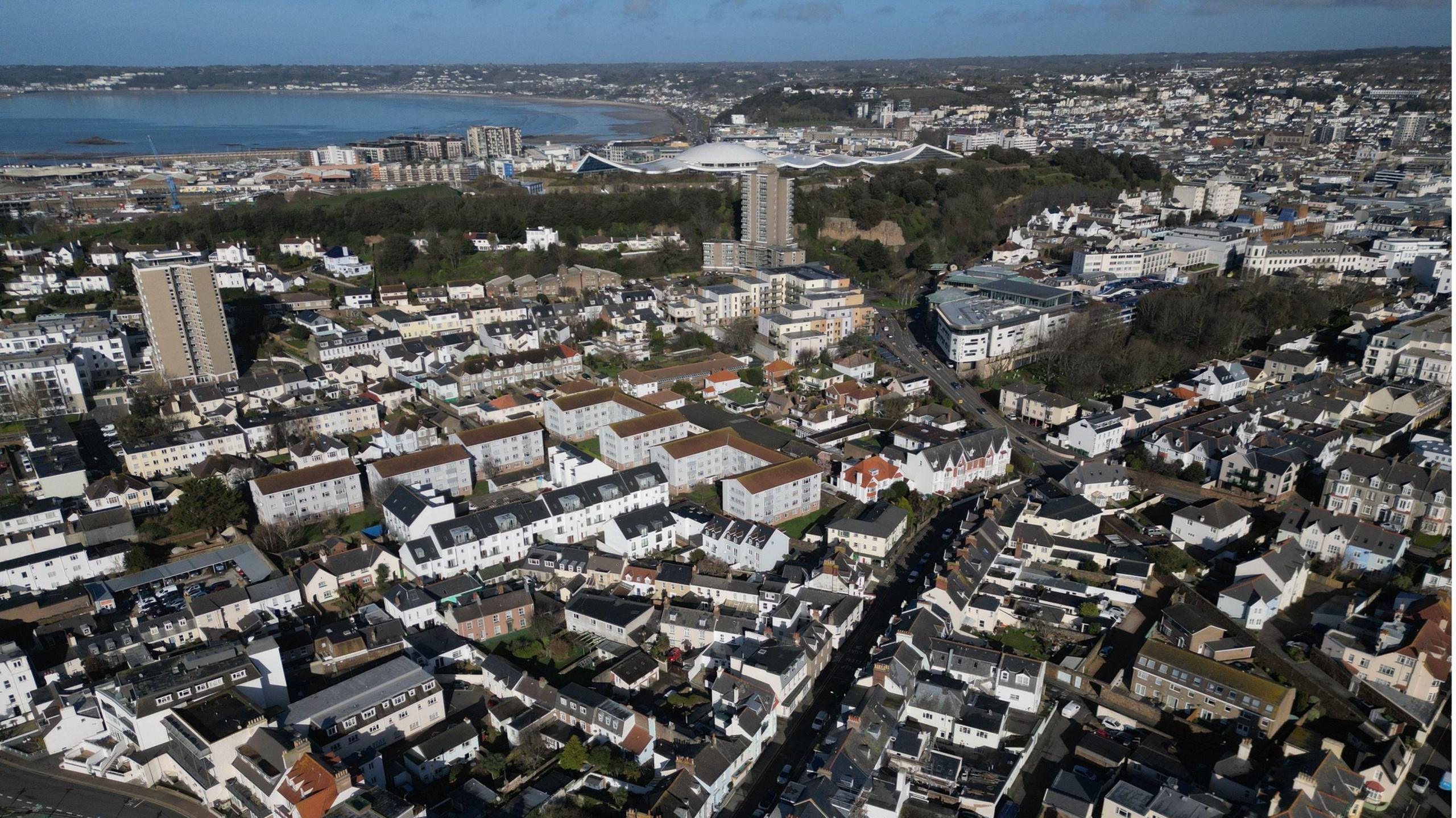 A picture taken from above of Jersey. Houses can be seen alongside green land and beaches in the distance.