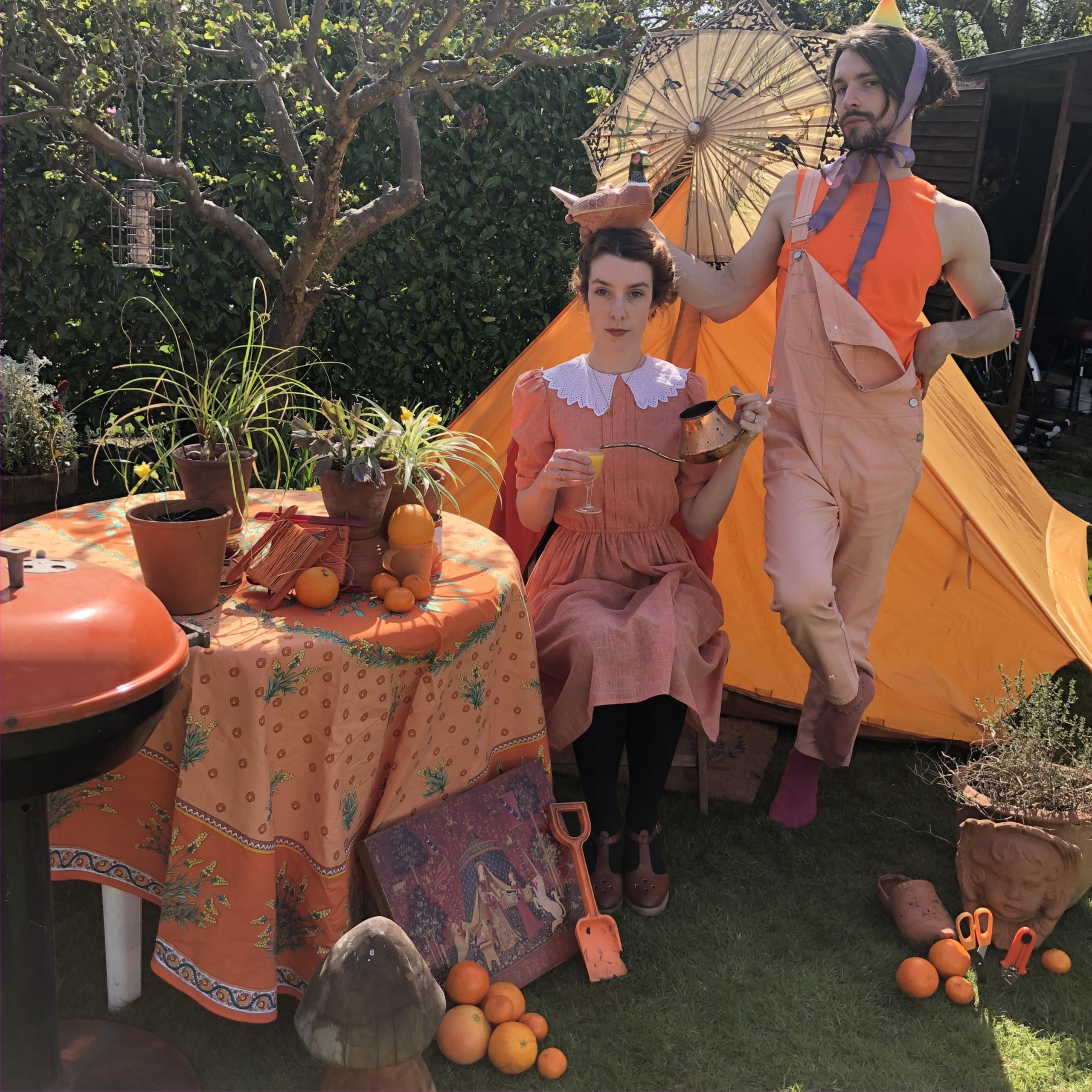 Helen Yang and Thomas Etheridge in orange outfits