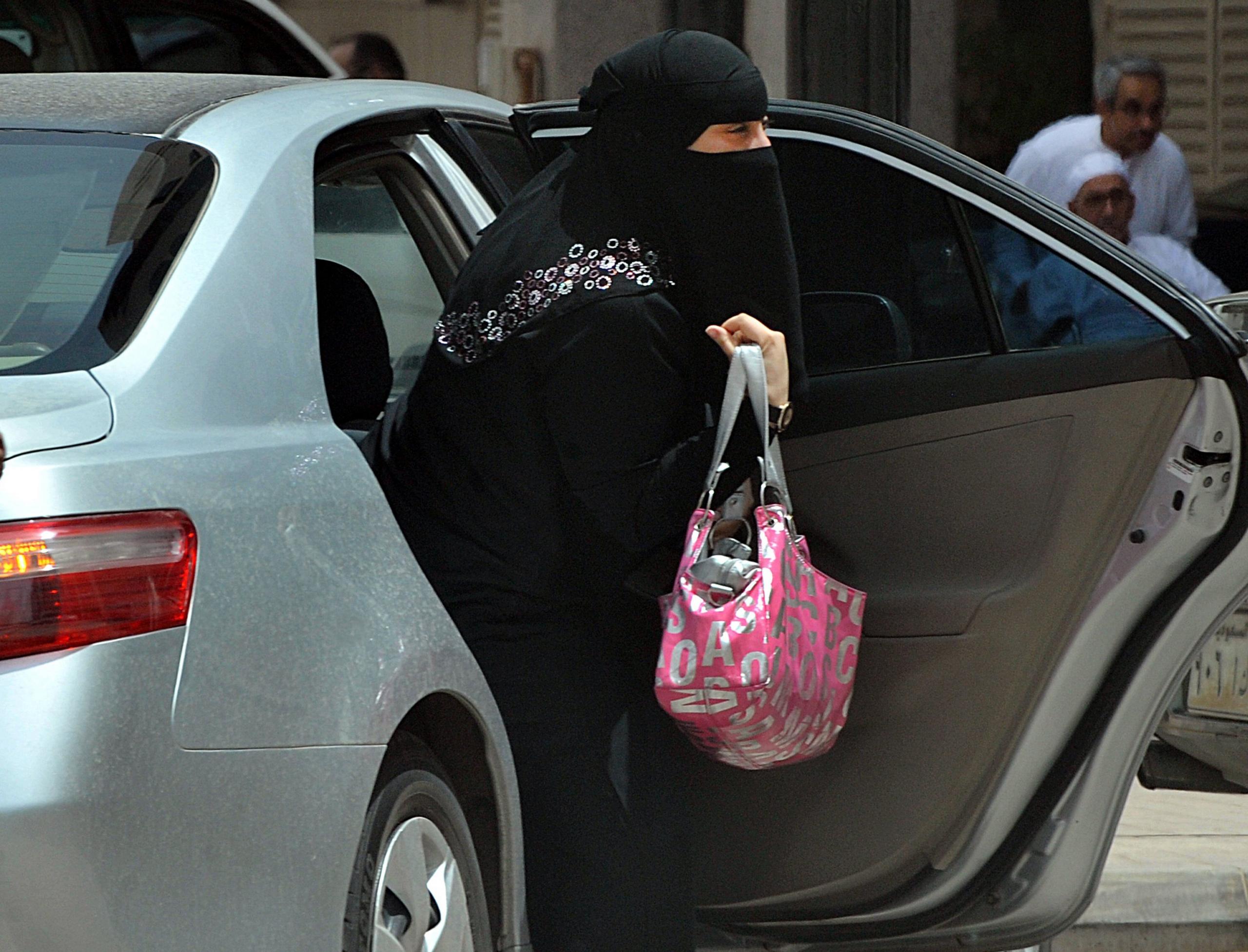 A Saudi woman gets out of a car after being given a ride by her driver in Riyadh on 26 May, 2011