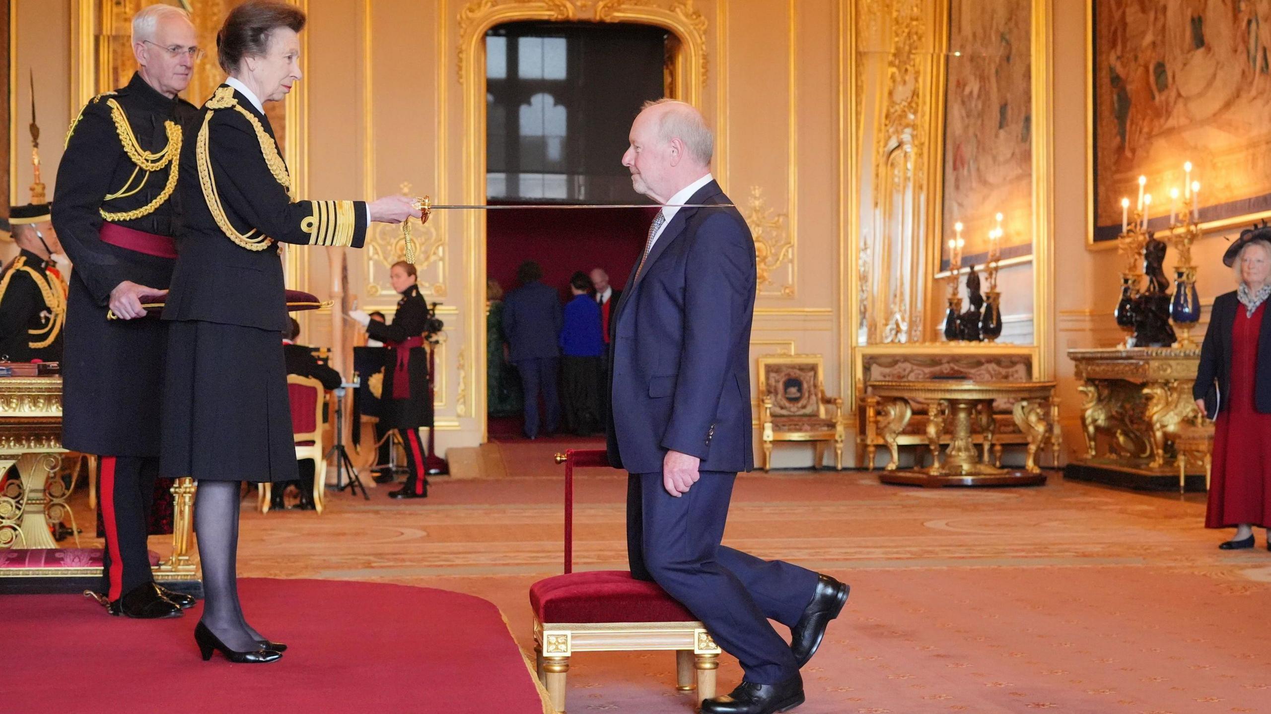 Alan Bates was given the honour by the Princess Royal who is holding the sword