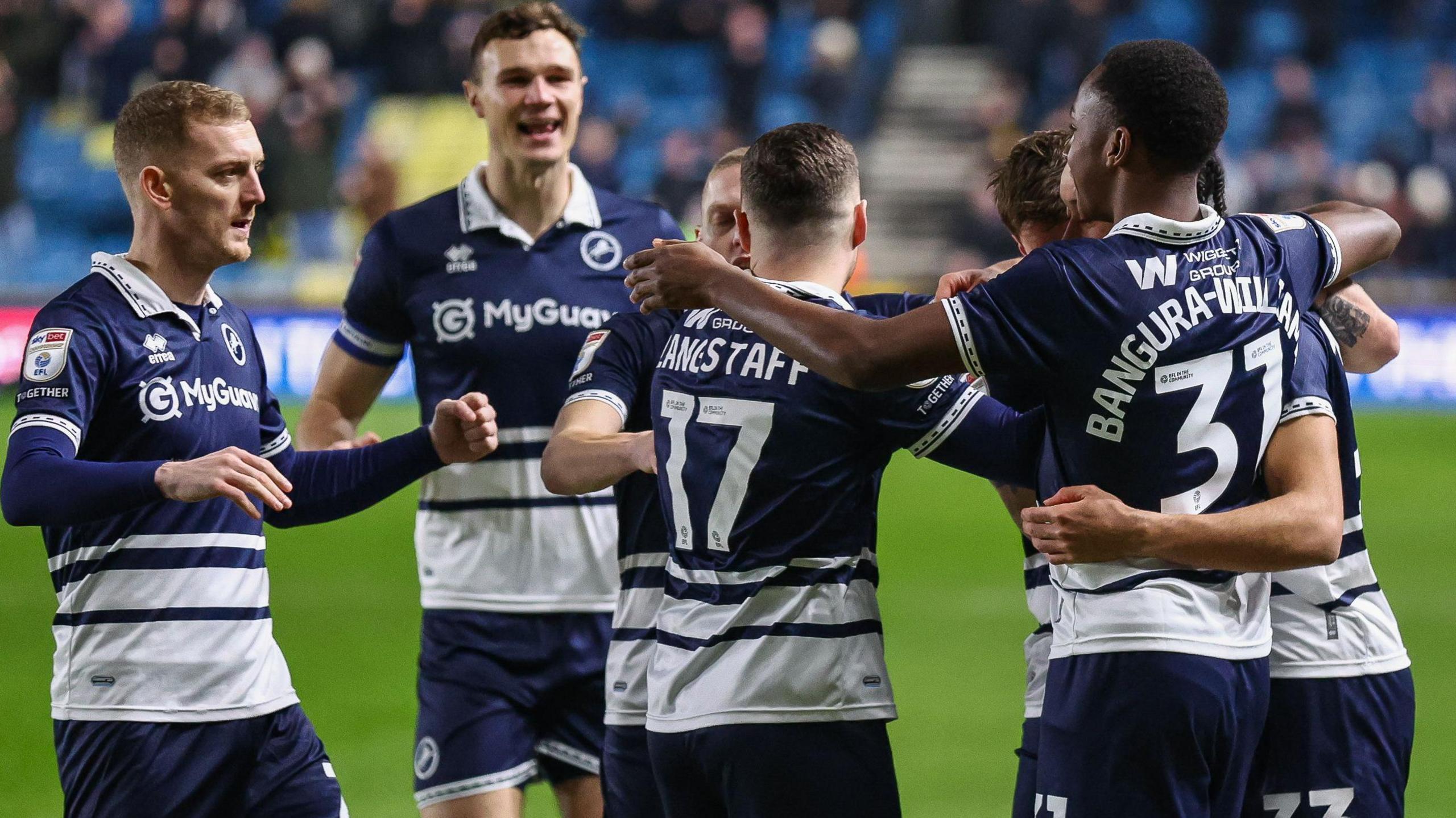 Millwall players celebrate in a huddle after Calum Scanlon [in huddle] scores against Cardiff City