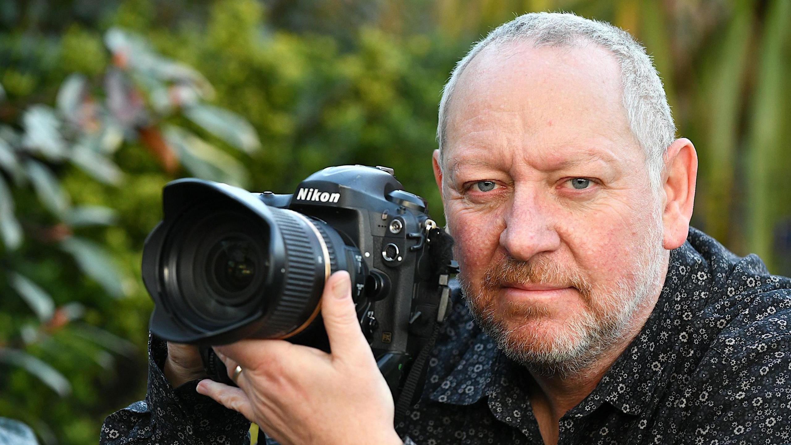 A man posing with his camera