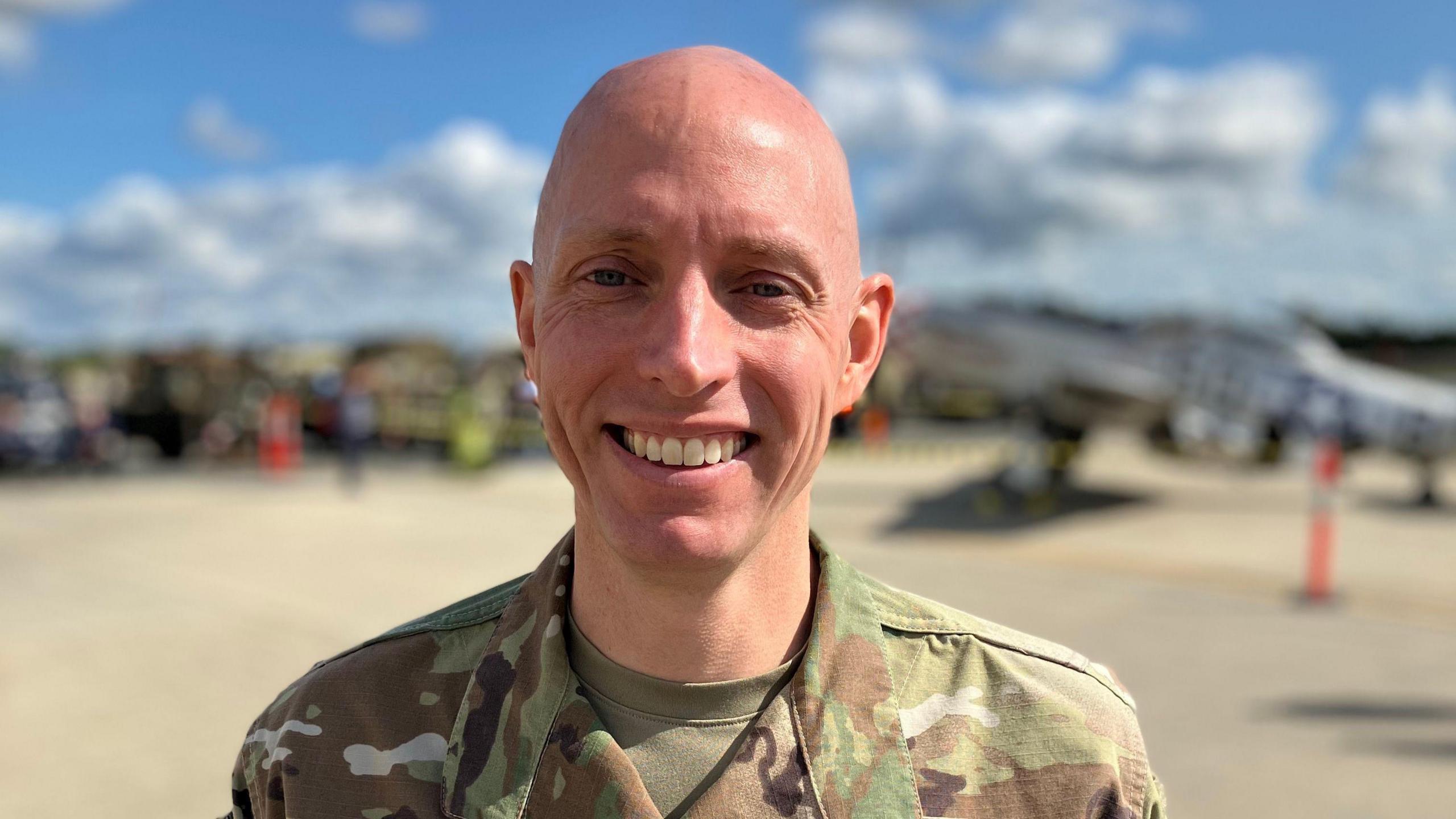 A US Air Force colonel in green camoflauge uniform with Fairford air base in the background