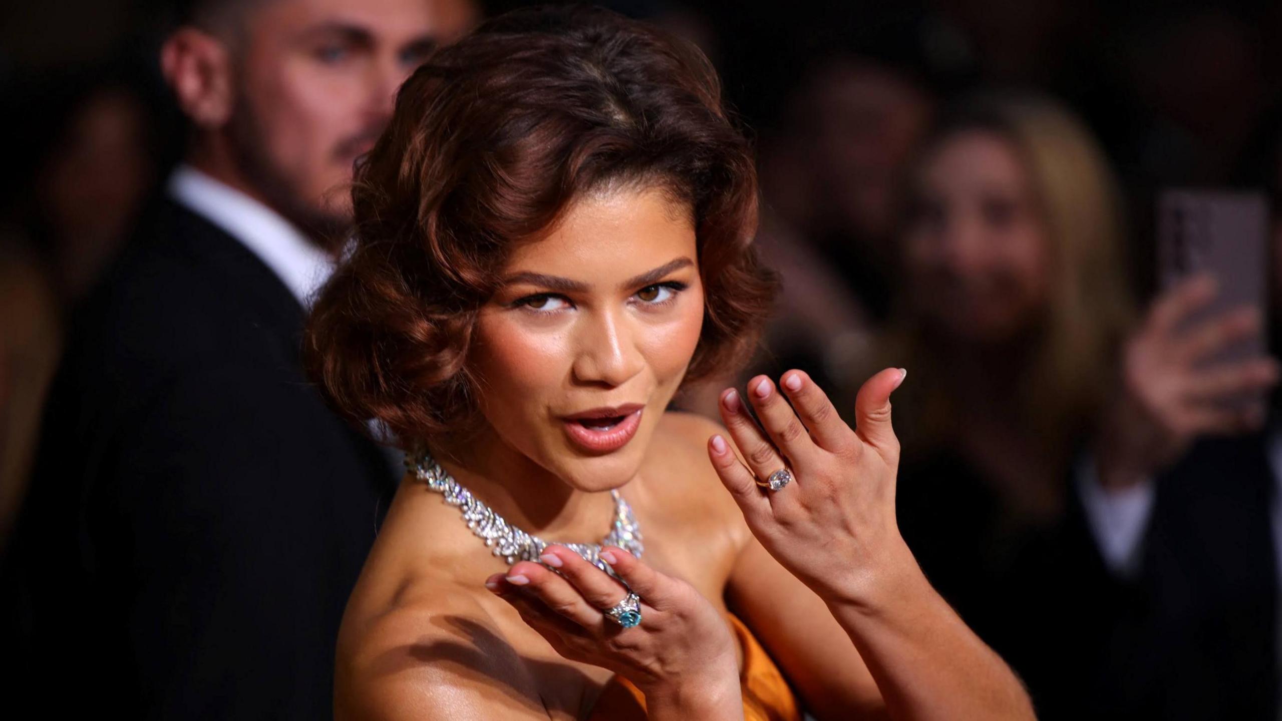 Zendaya shows off the rings on both hands as she poses on the red carpet