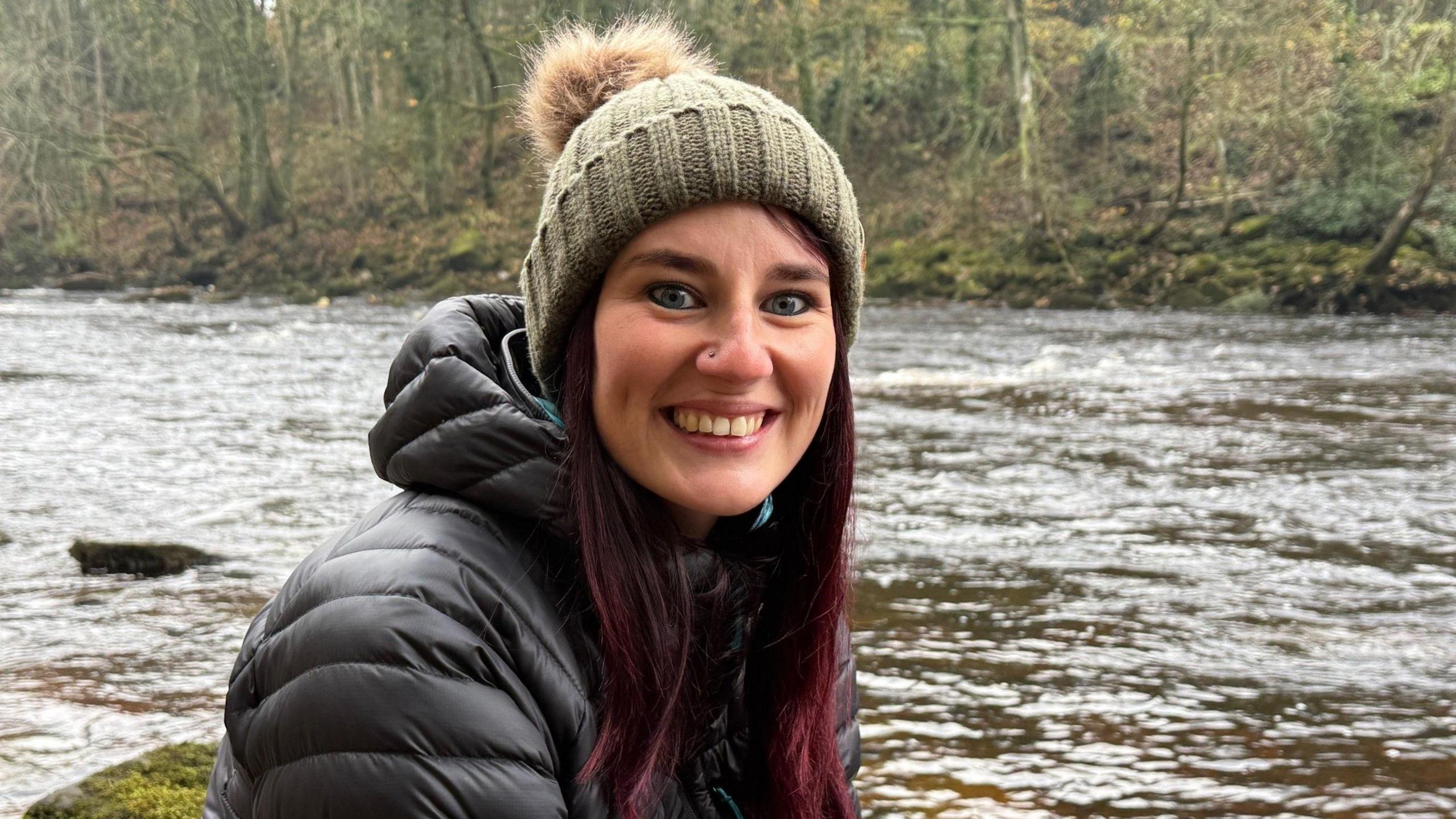 A young woman beside a river