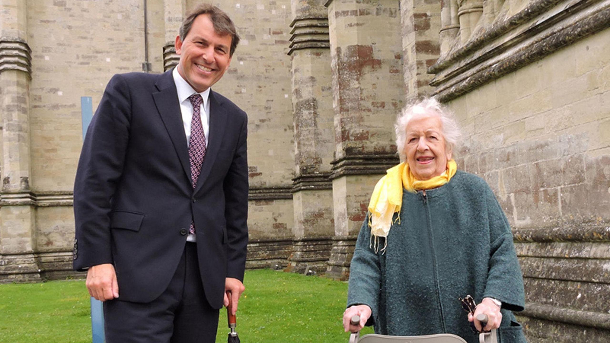 Phyll with Salisbury MP John Glen standing outside Salisbury Cathedral on a patch of grass