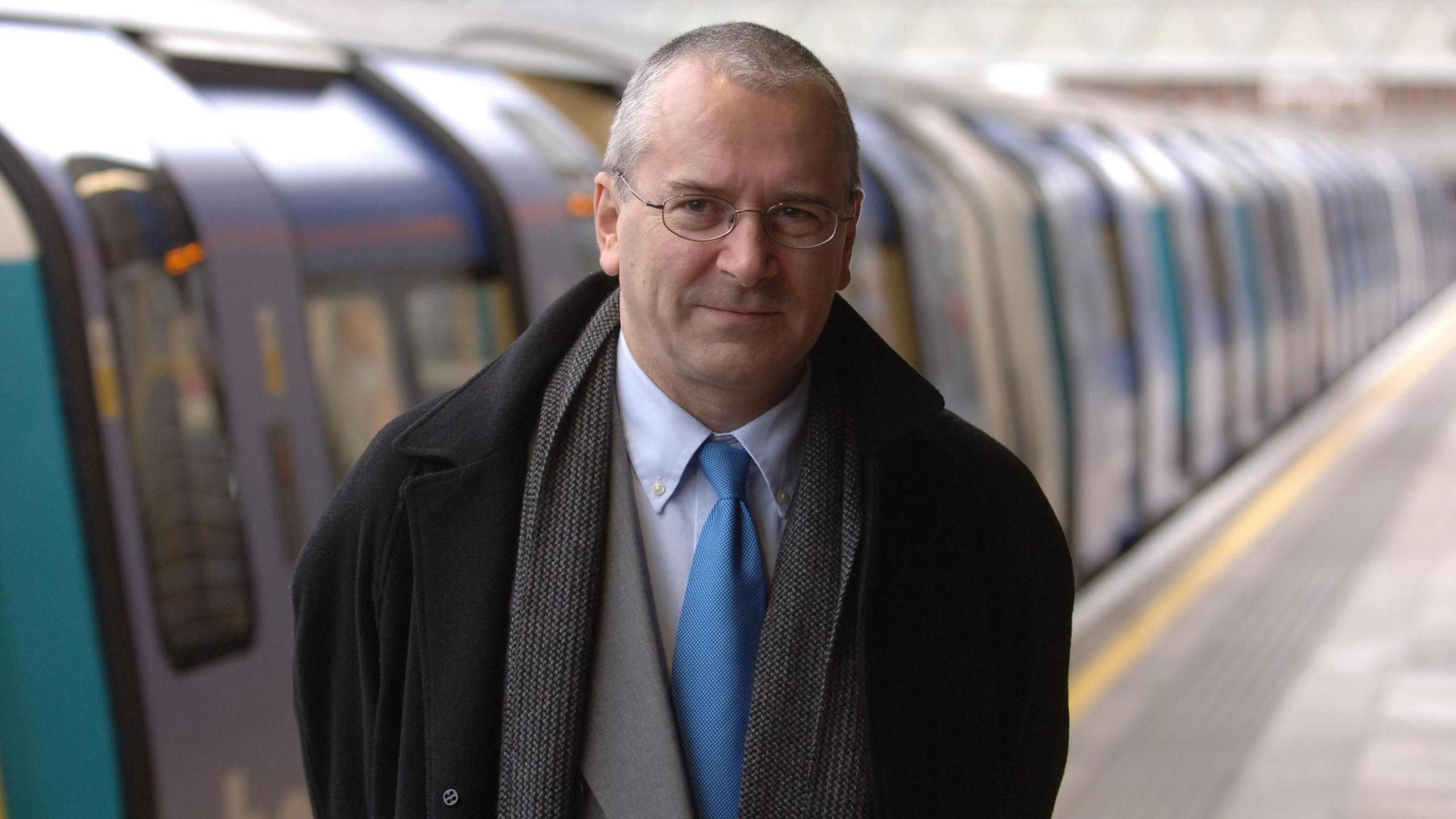 Lord Peter Handy photographed on a train station, in front of a train