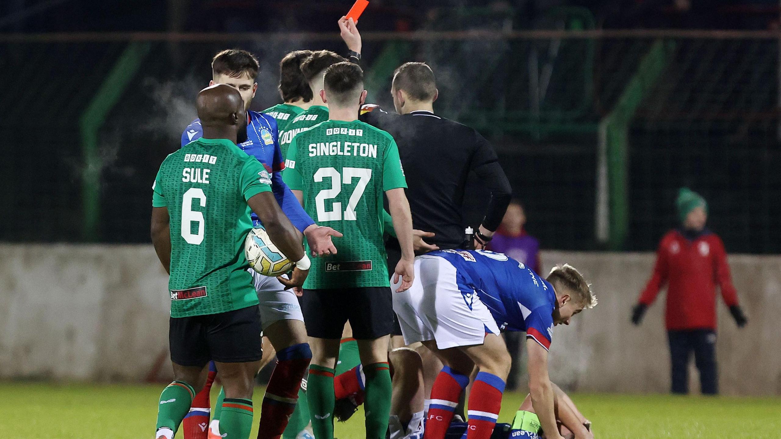 Tim Marshall shows James Douglas a red card as Jamie Mulgrew lies injured