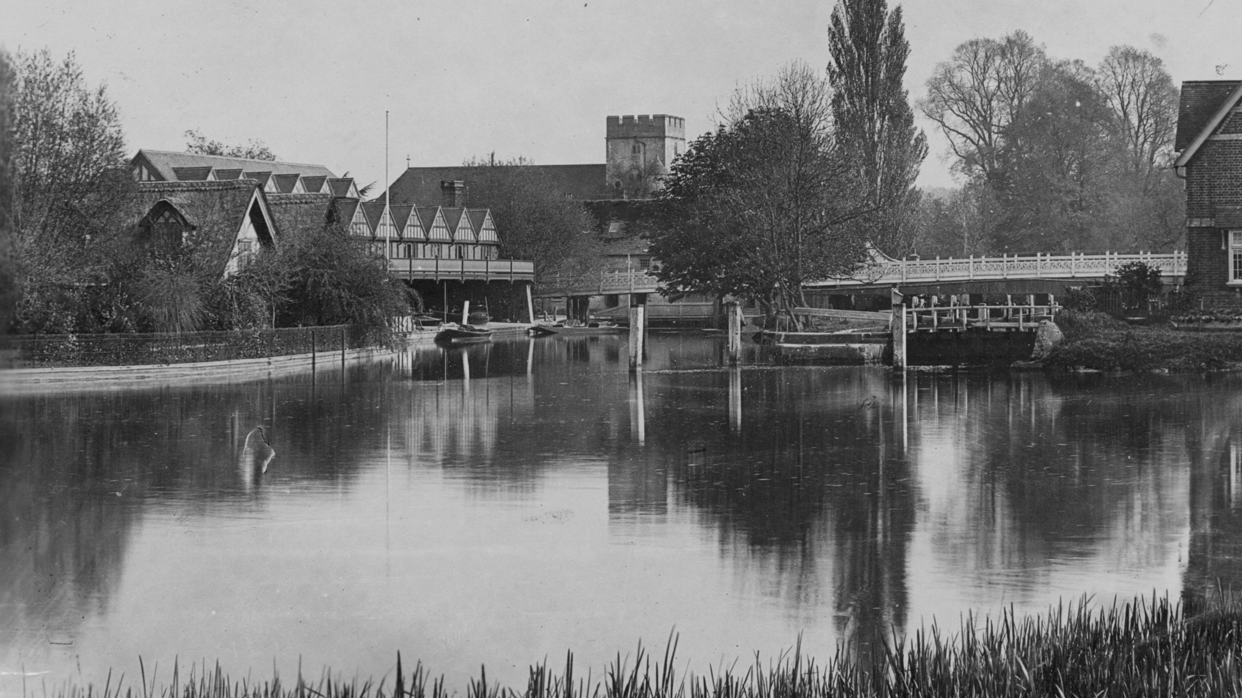 A historic photograph showing the boathouse in the late 19th Century, taken from across the river. It looks much the same, though there are much less vessels on the water.
