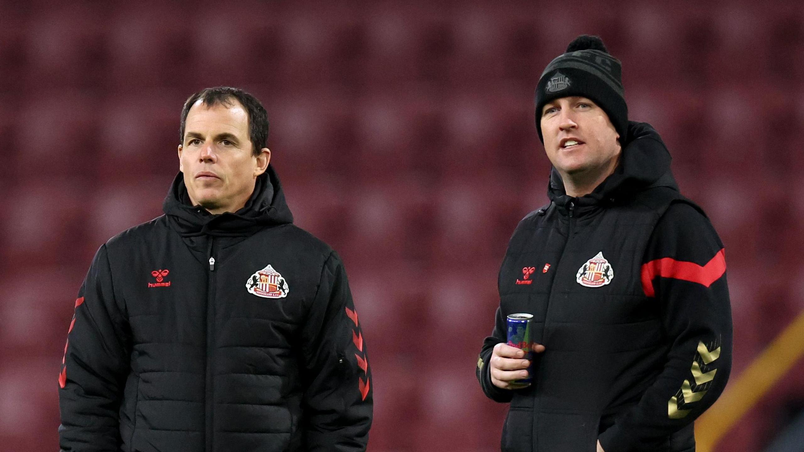 Regis Le Bris and Mike Dodds, holding a drink, on the pitch ahead of Sunderland's match at Burnley