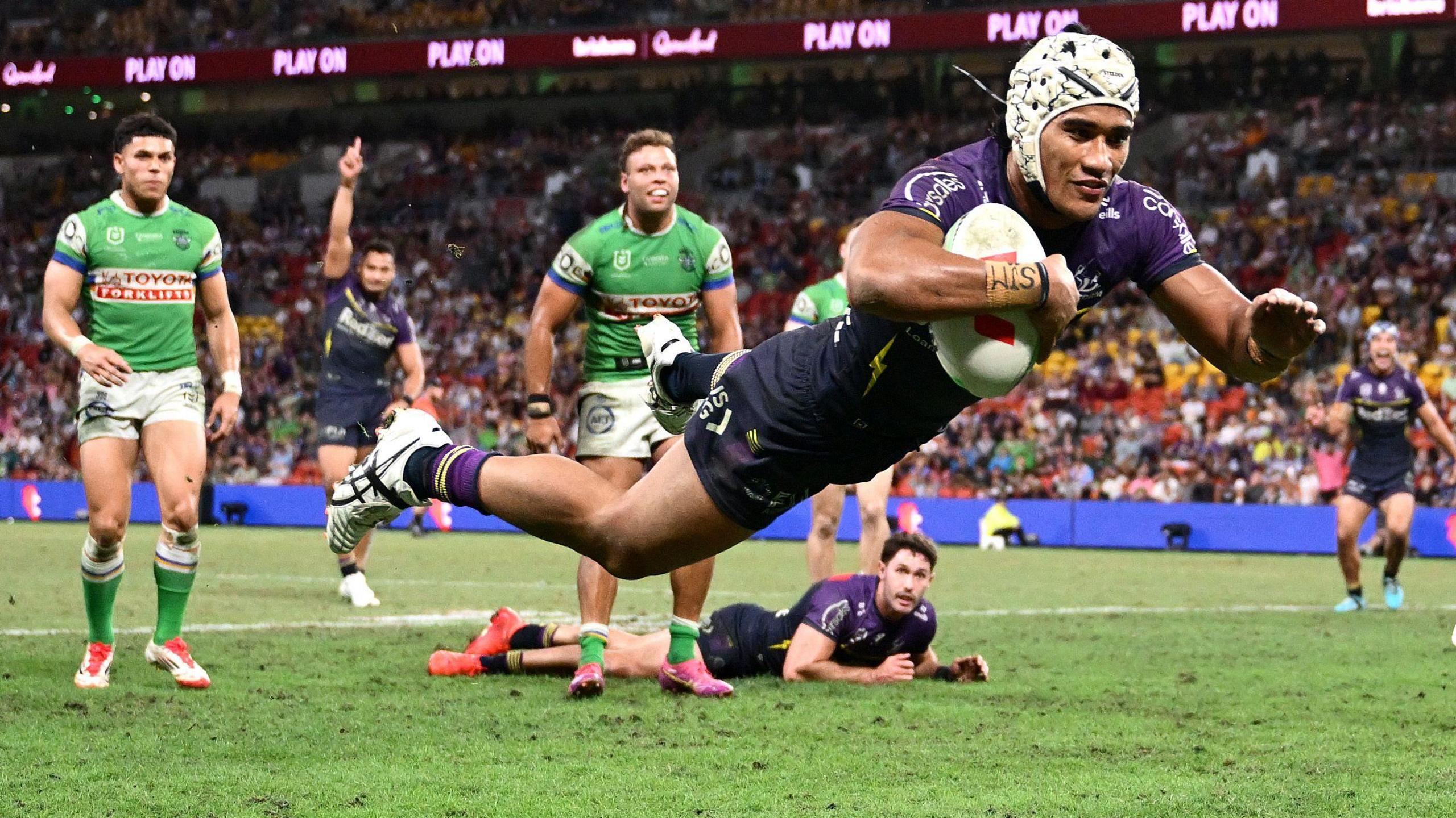 Melbourne Storm's Sualauvi Faalogo dives over to score a try during the round nine NRL match against Canberra Raiders at Suncorp Stadium in Brisbane, Australia