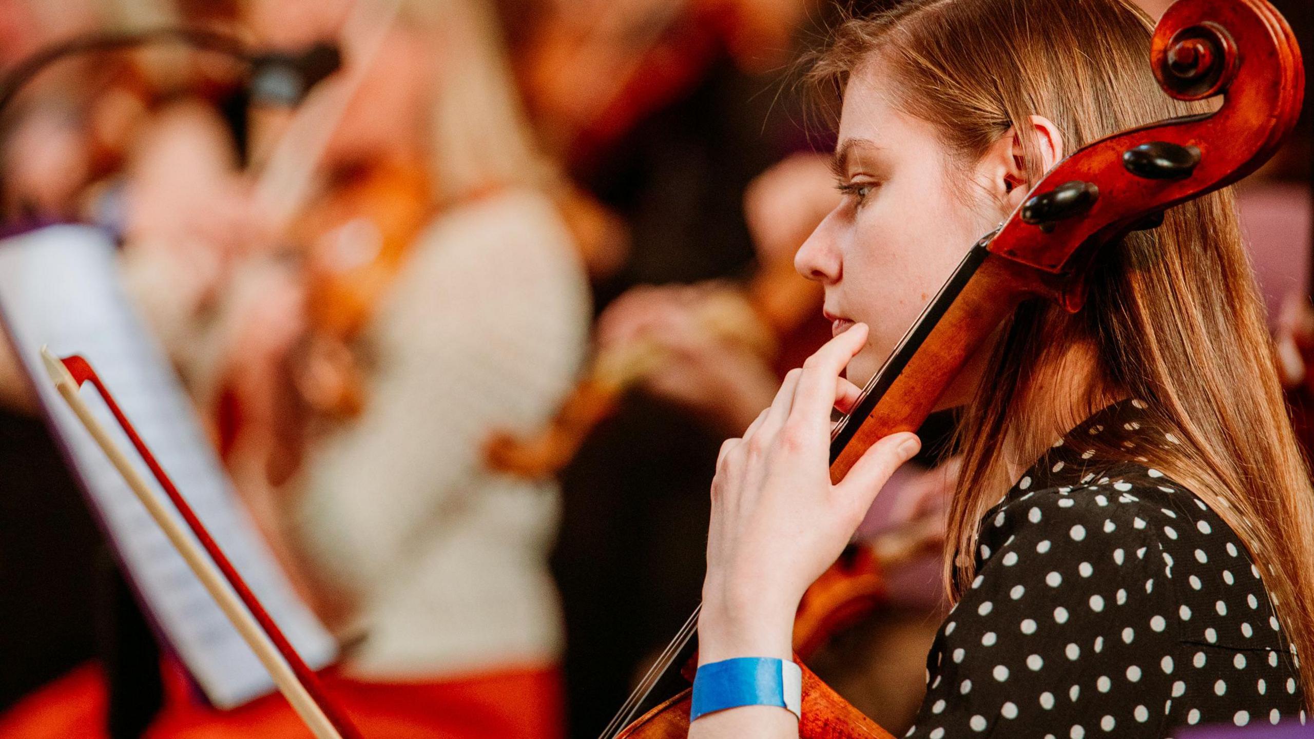 A young woman playing a cello during the Bristol Beacon event at Bristol Cathedral