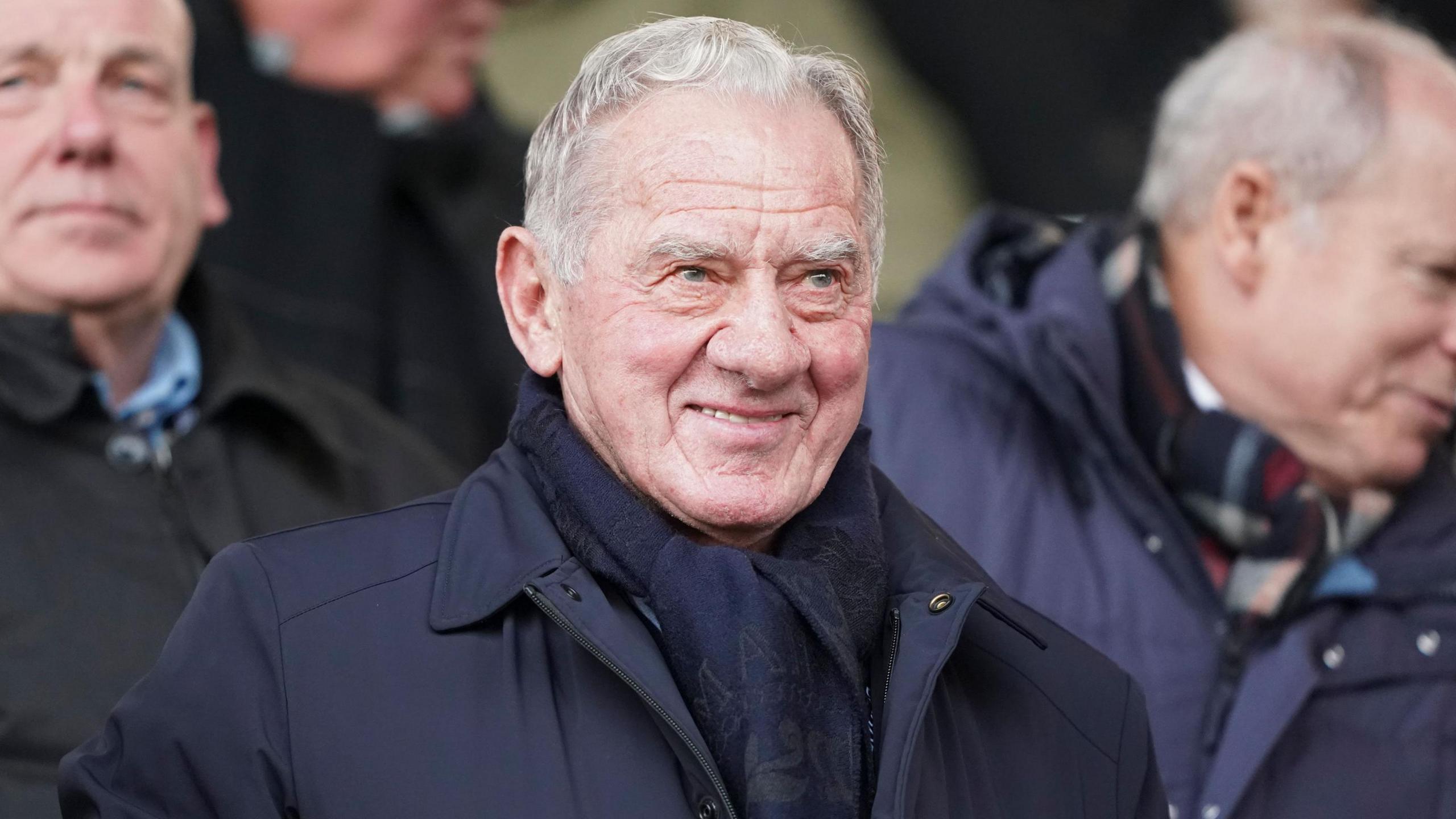 A grey-haired Milan Mandaric pictured wearing a dark coat while attending a football match