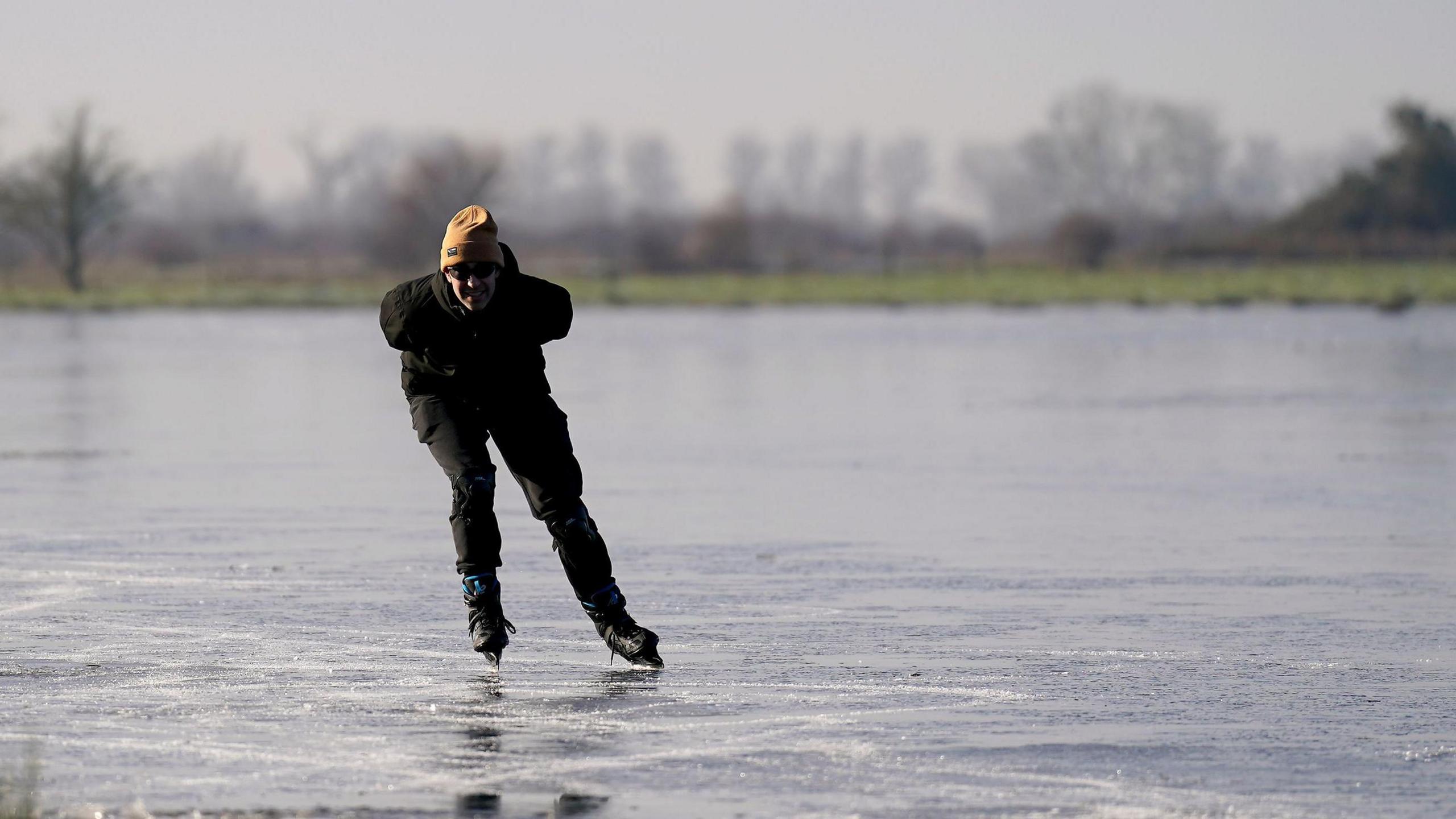 Ugo Sassi from Cambridge skates on a frozen flooded field in Upware, Cambridgeshire.