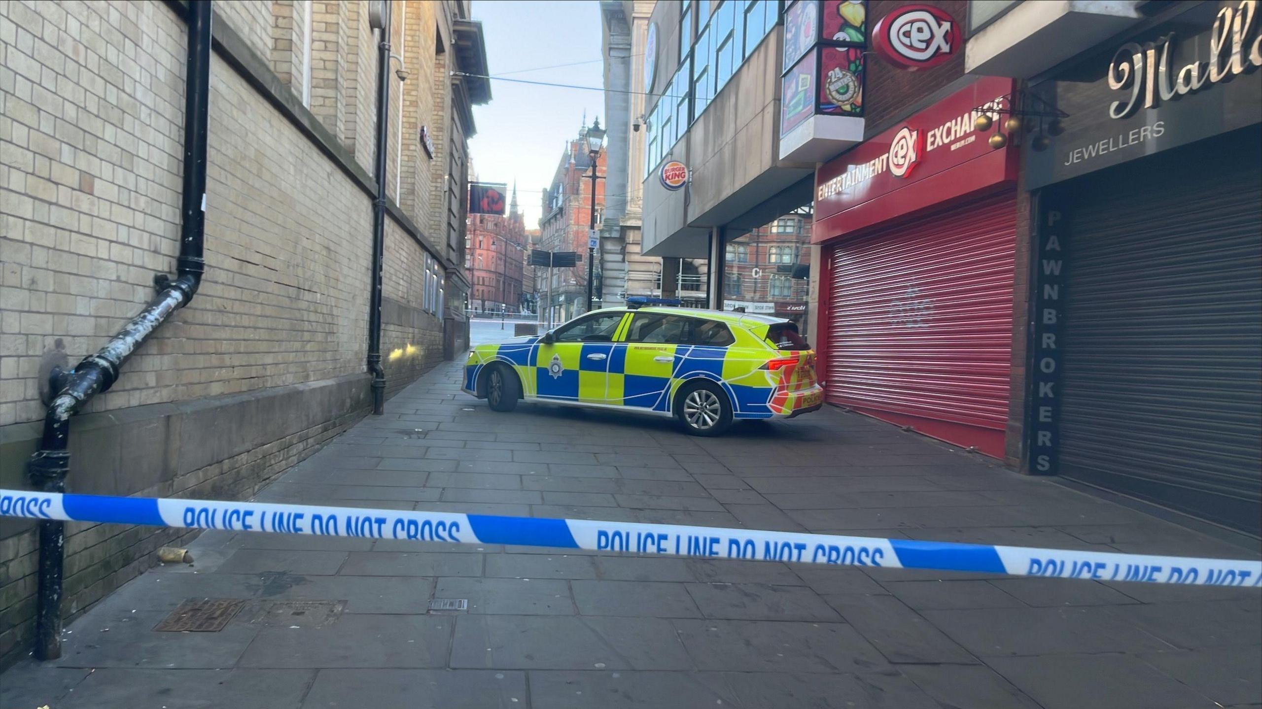 Police blocking an alleyway leading to the marketplace