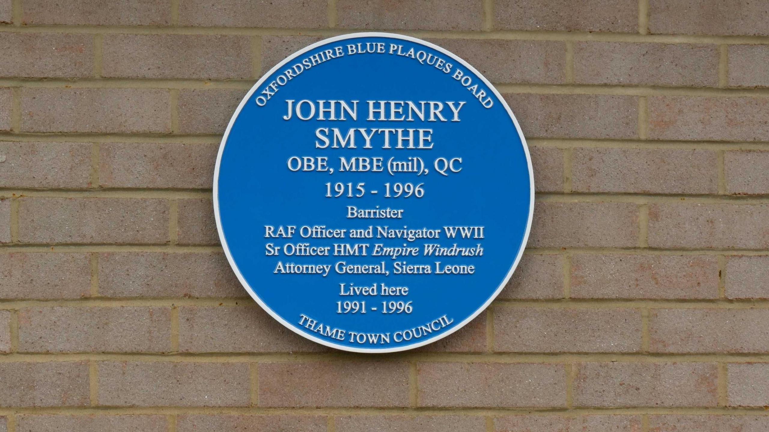 A blue plaque which reads John Henry Smythe OBE, MBE 1915 -1996.