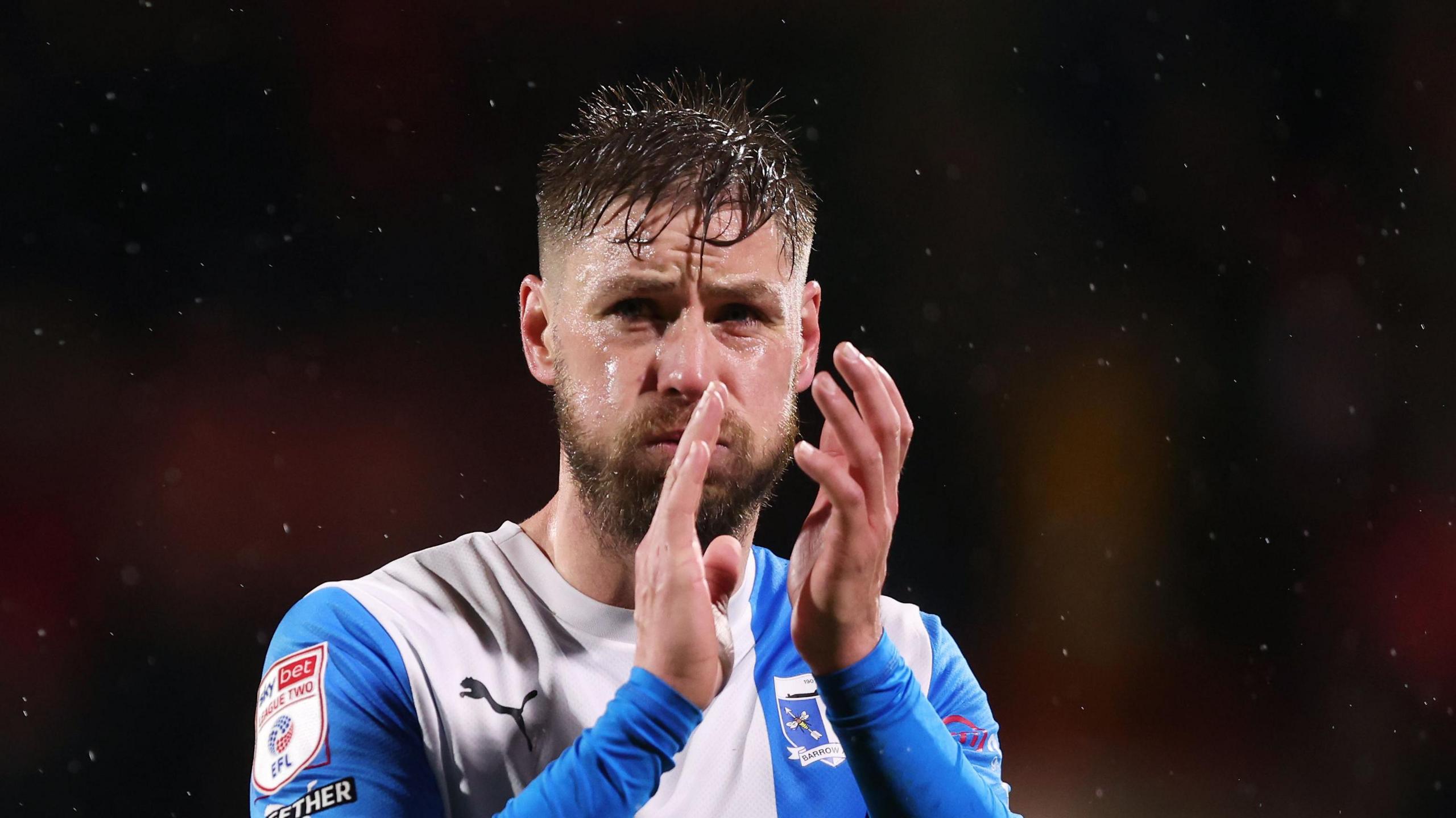 Barrow player Sam Foley applauding his club's supporters 