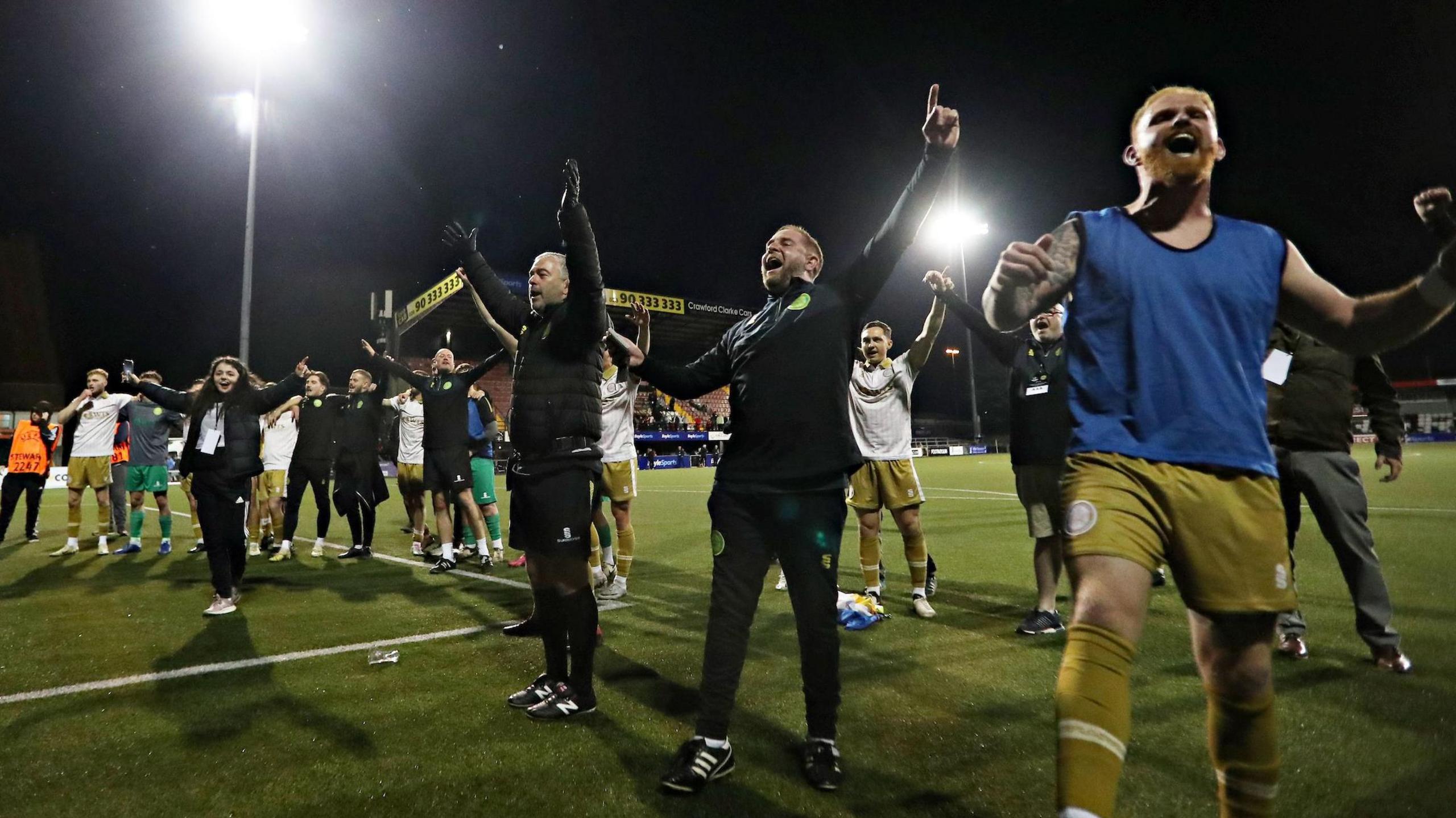 Caernarfon Town players and officials celebrate the win over Crusaders