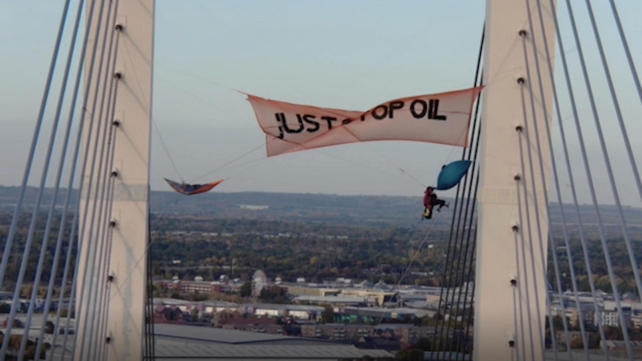 Shot of two protesters hanging from Dartford Crossing Bridge