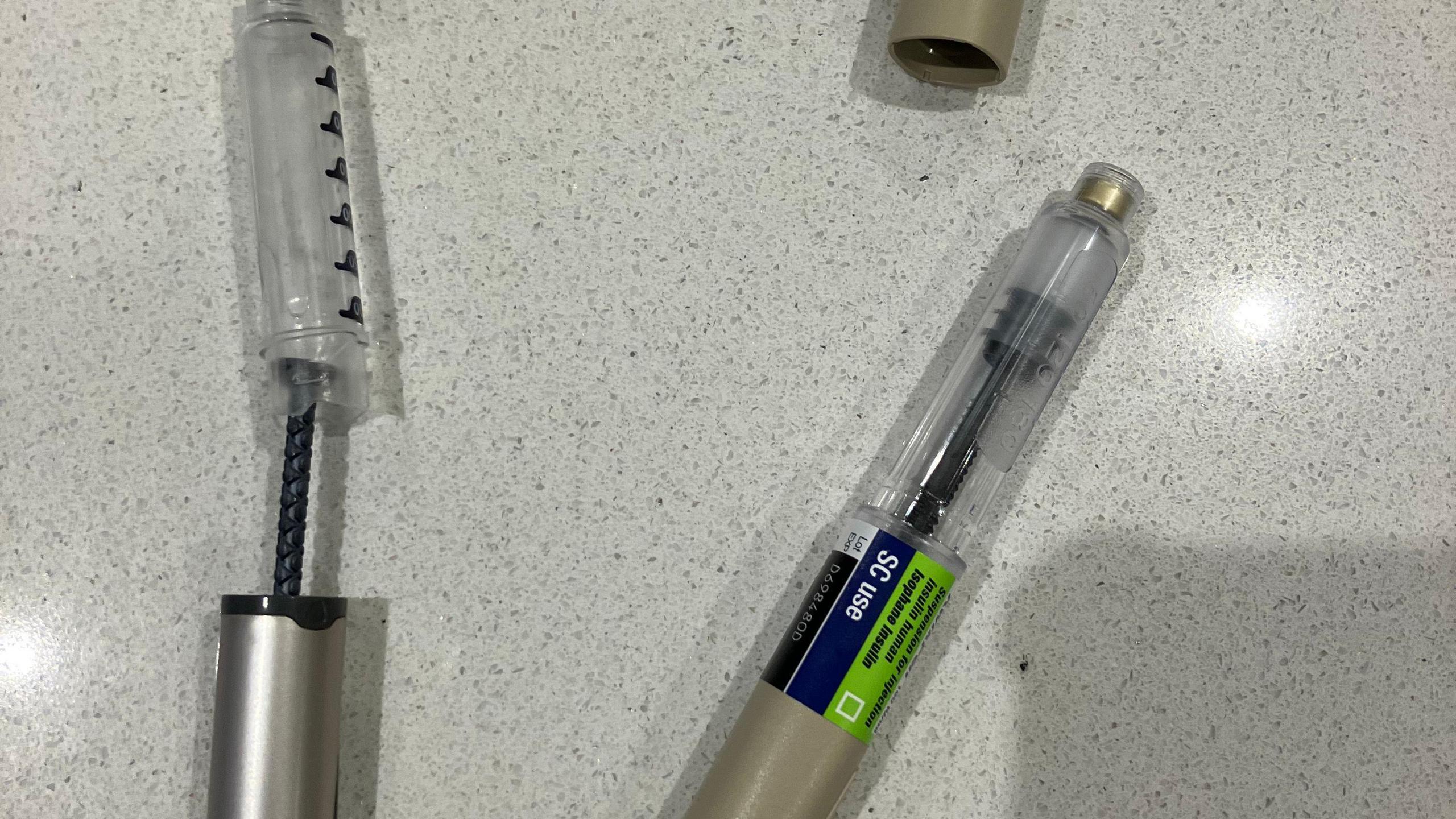 Two different types of insulin pen are shown, one has a silver casing and the other is plastic