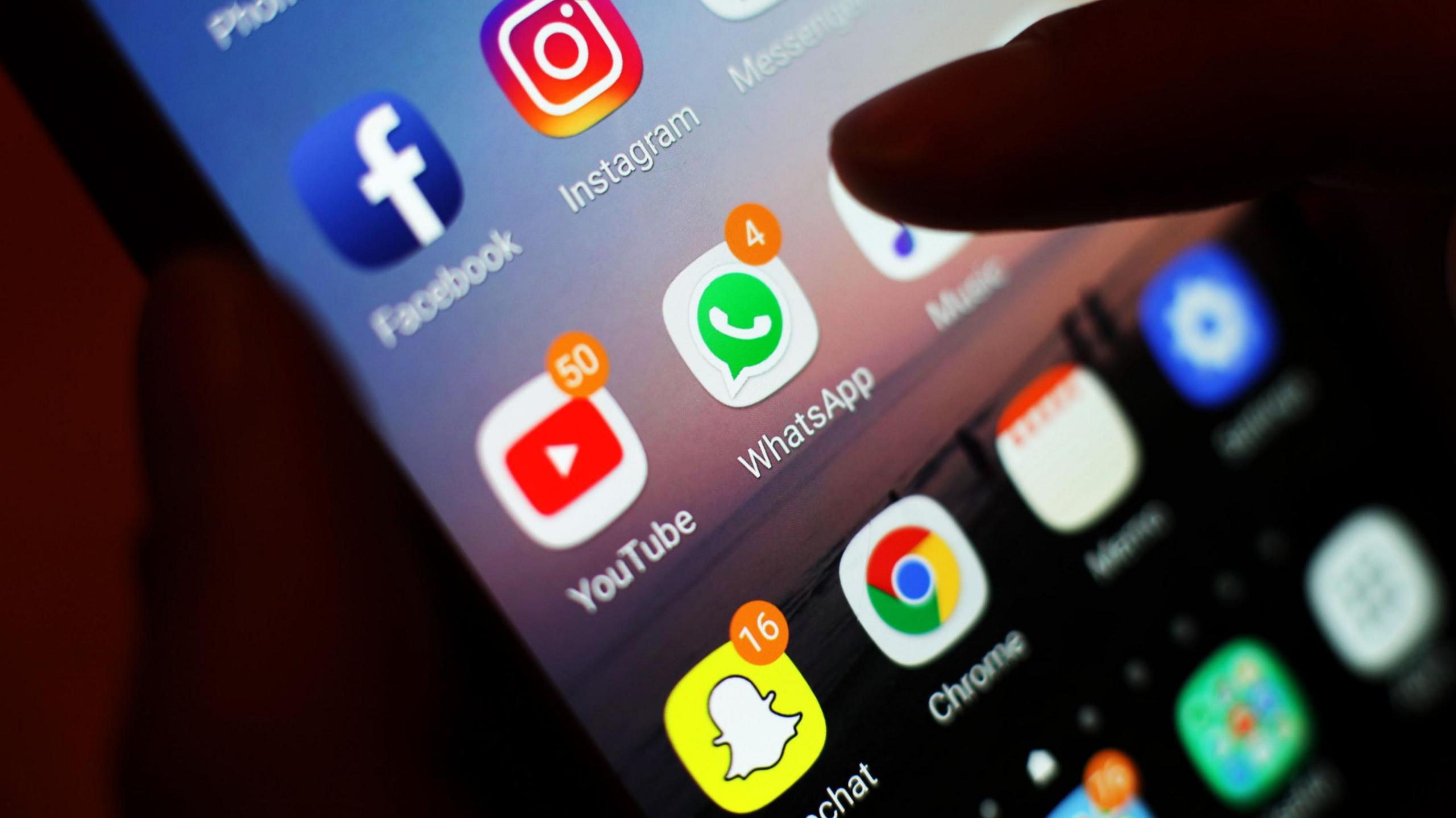 Sgrin ffôn gyda nifer o apiau cyfryngau cymdeithasol arno, gan gynnwys Snapchat ac Instagram